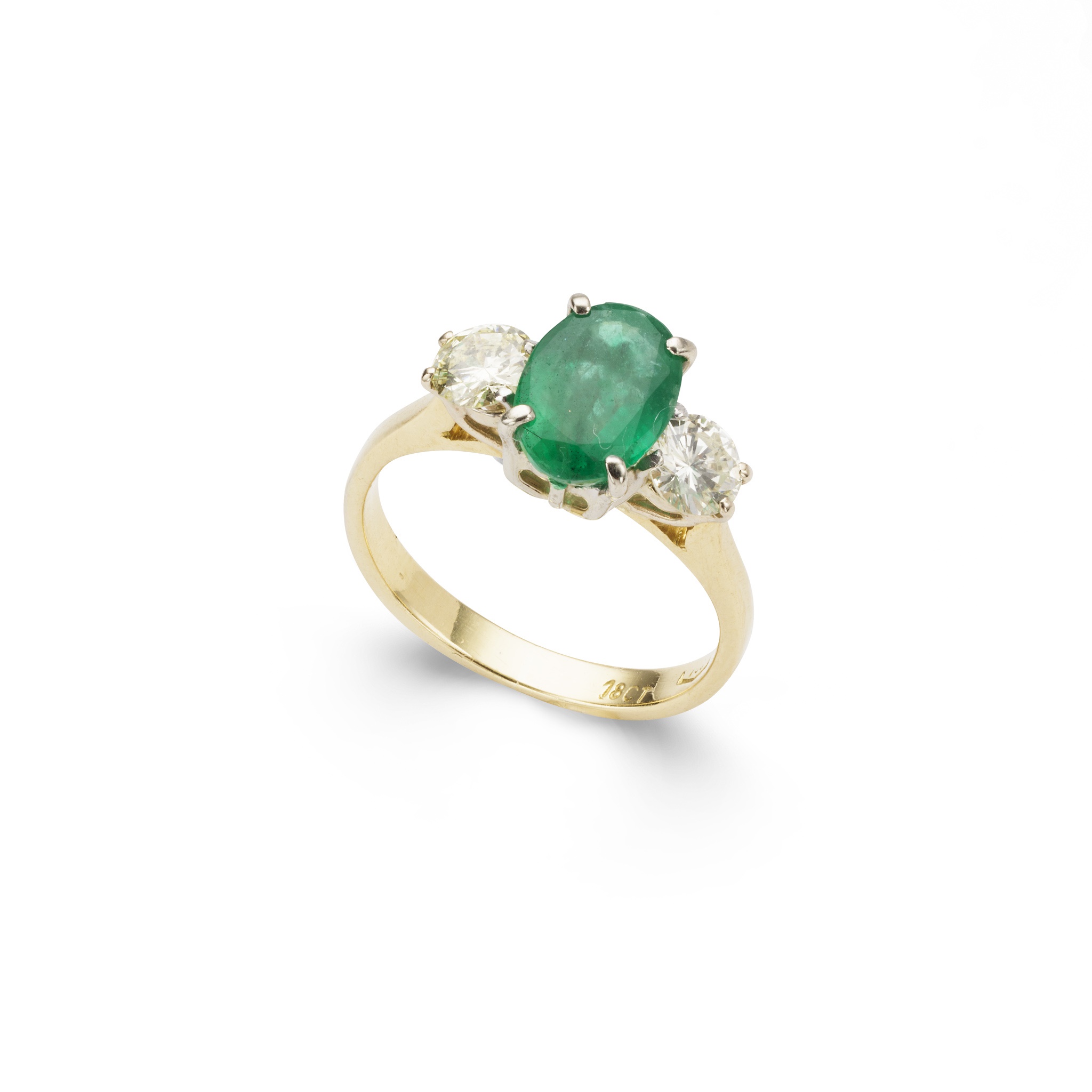 An emerald and diamond three-stone ring