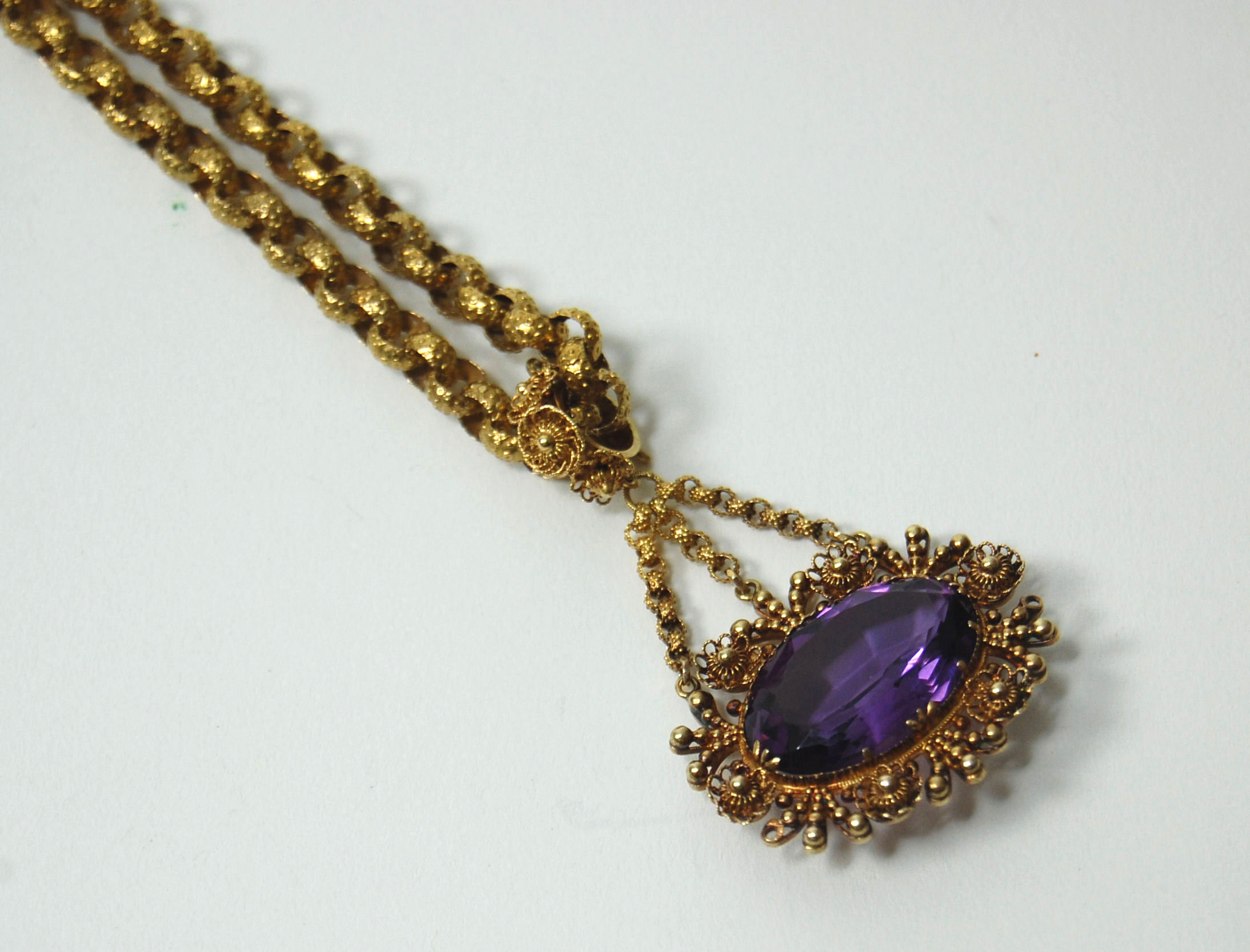 A Georgian gold long chain with amethyst set pendant,