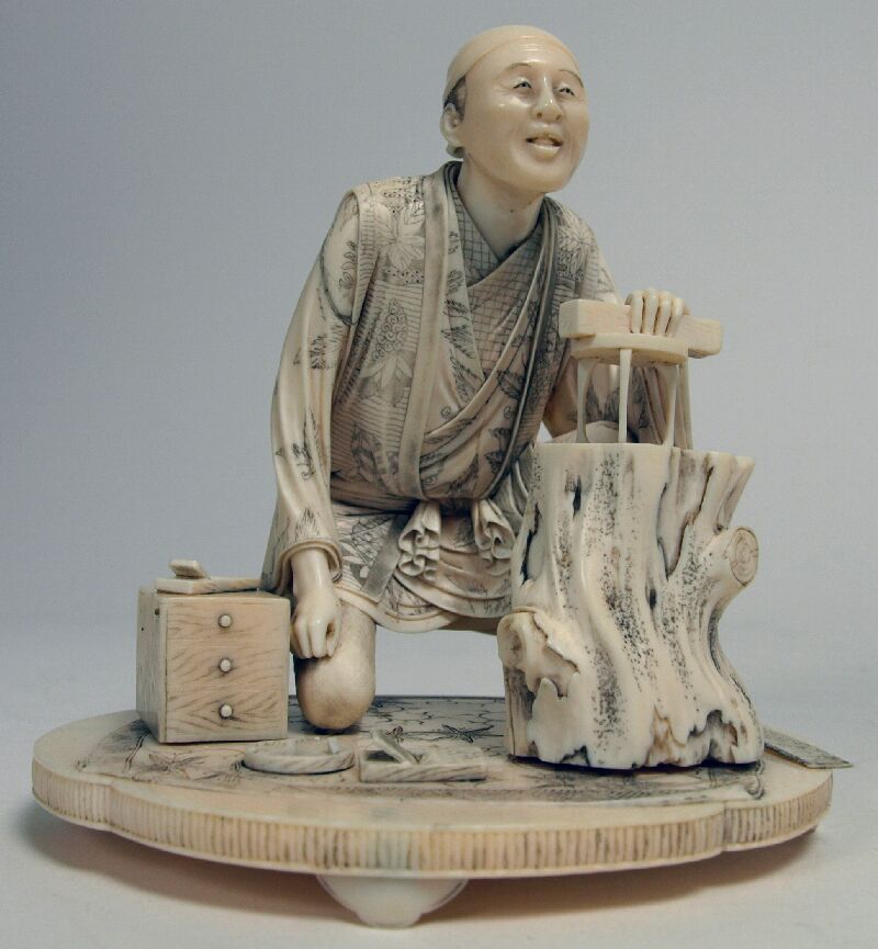 A Japanese carved ivory okimono of a carpenter, Meiji period