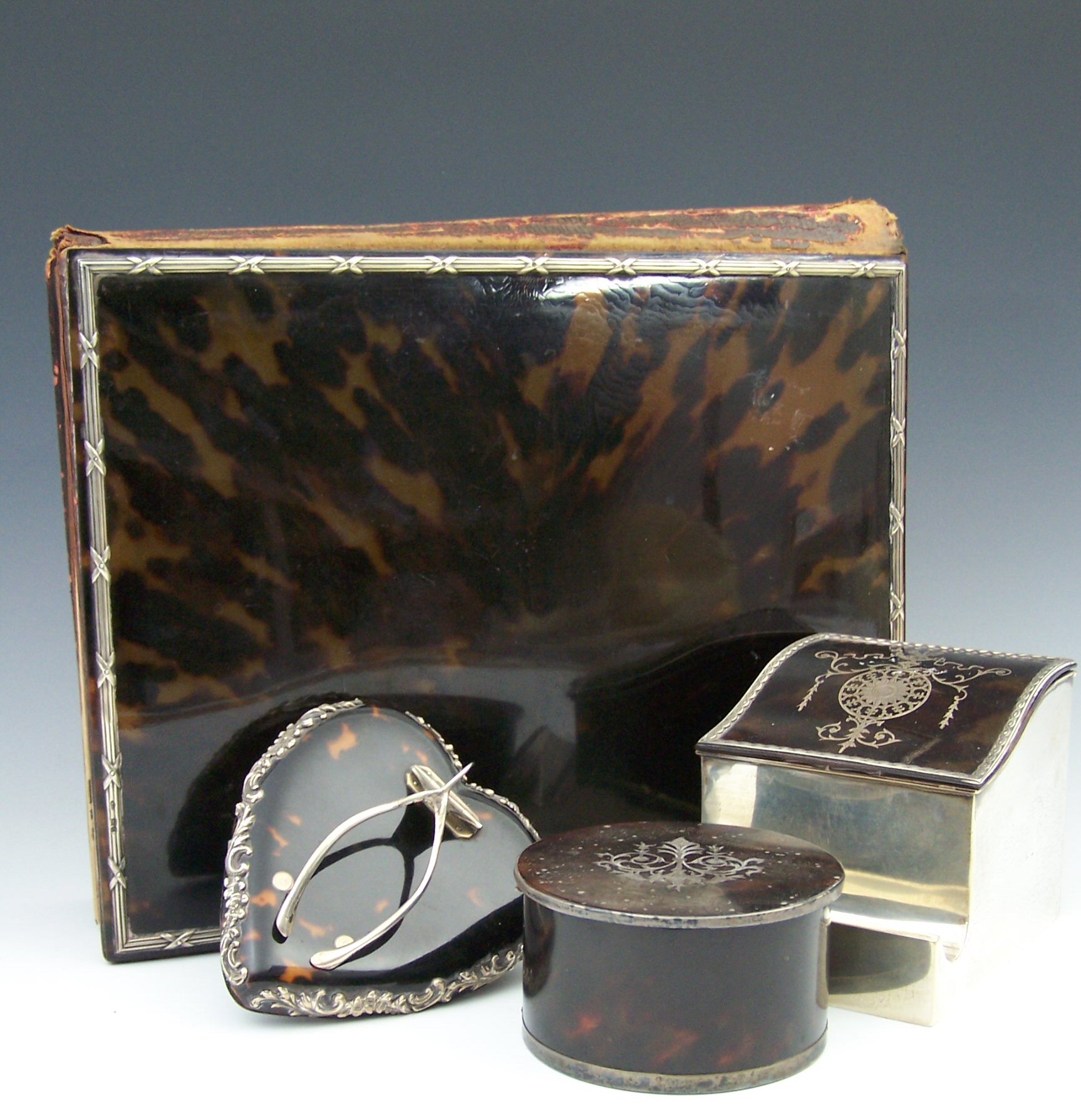 A collection of tortoiseshell and silver applied desk ornaments, circa 1900,