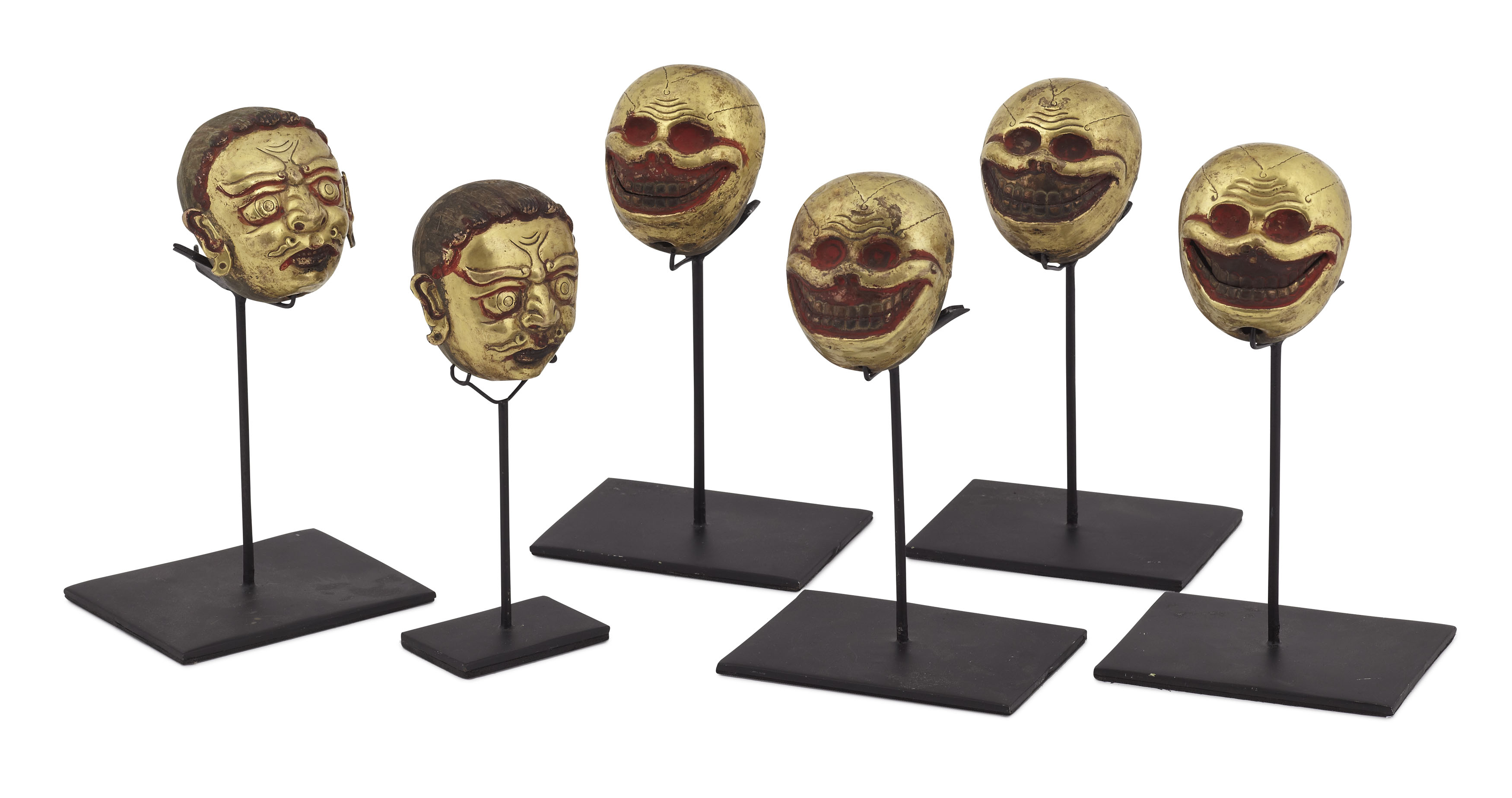 GROUP OF SIX TIBETAN GILT METAL HEADS OF DEMONS