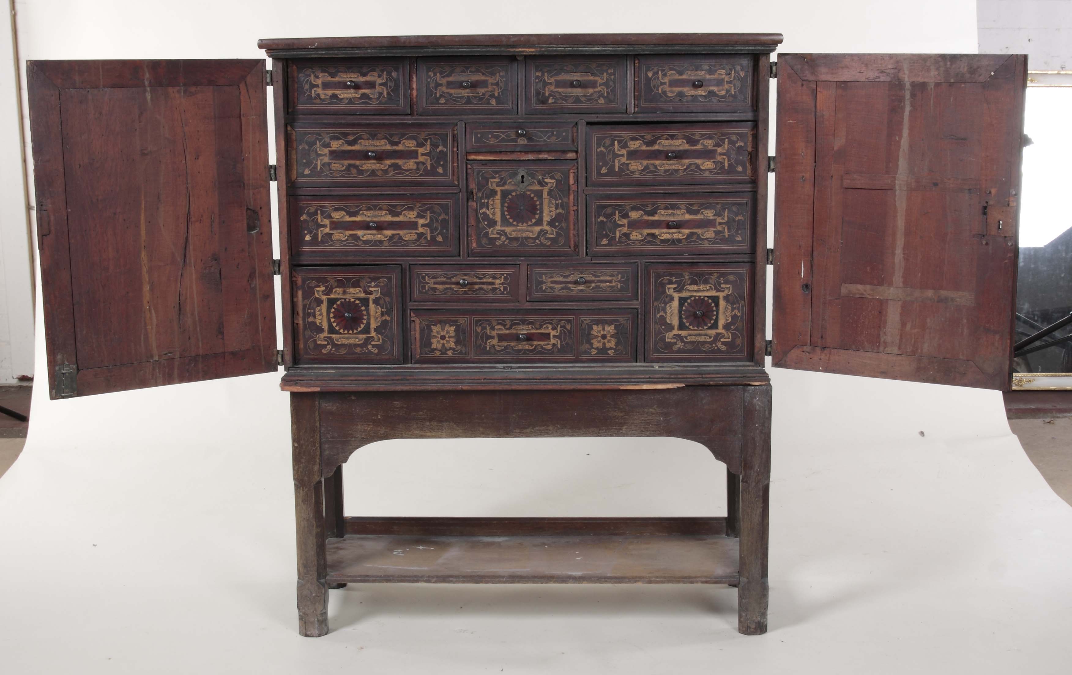 A late 17th/ early 18th century Iberian walnut cabinet, on later estate-built stand