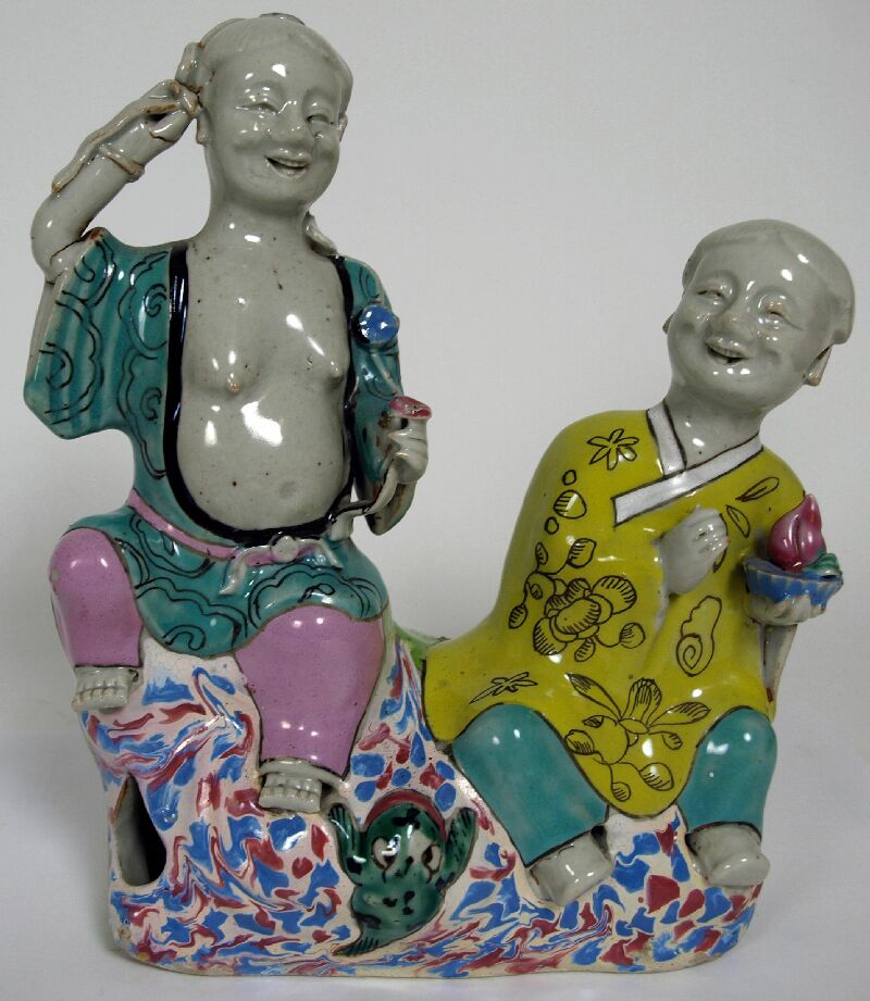 An 18th century Chinese famille rose figure group depicting the twin Genii of Harmony and Mirth