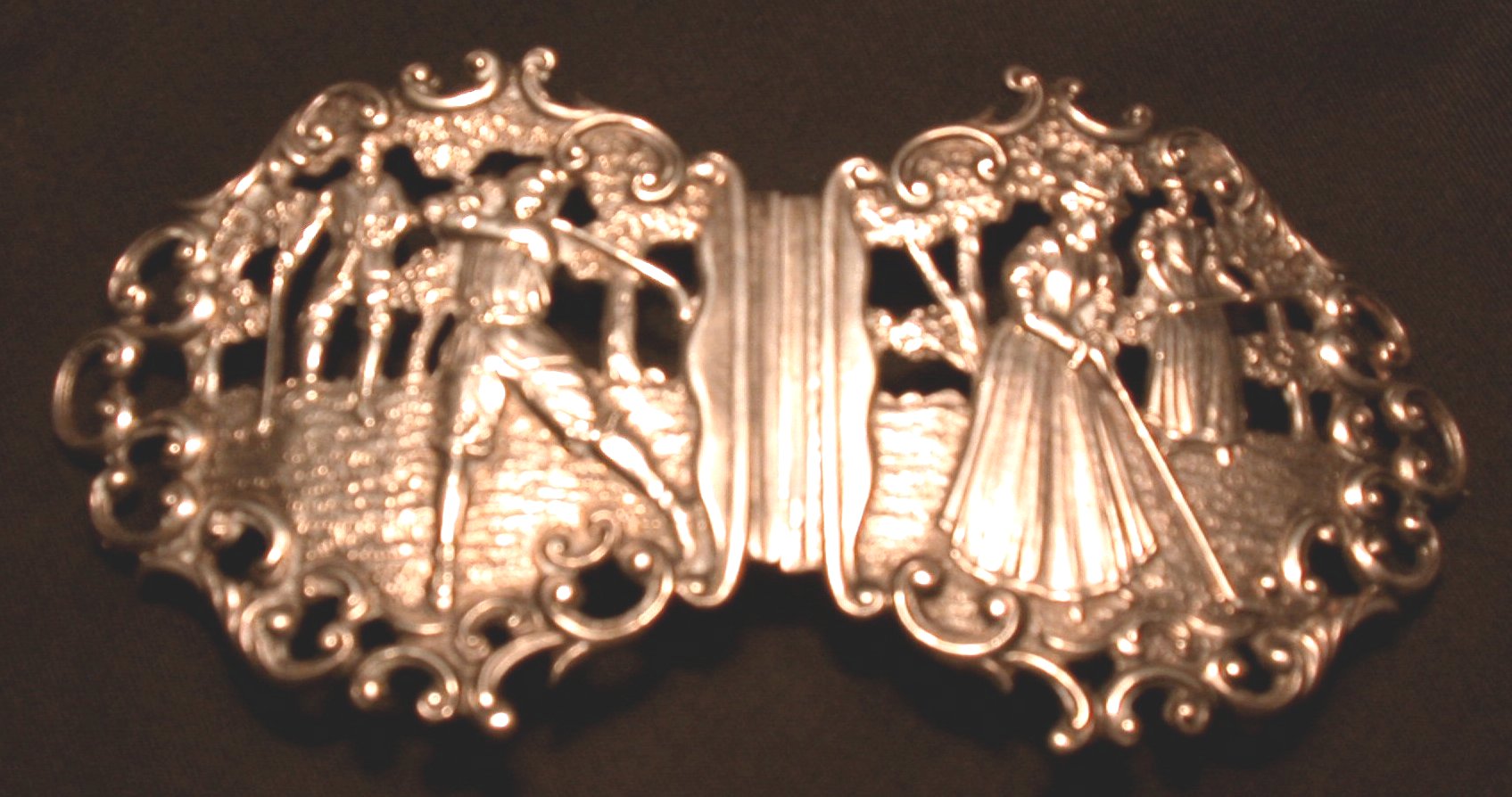 A silver golfing belt buckle,