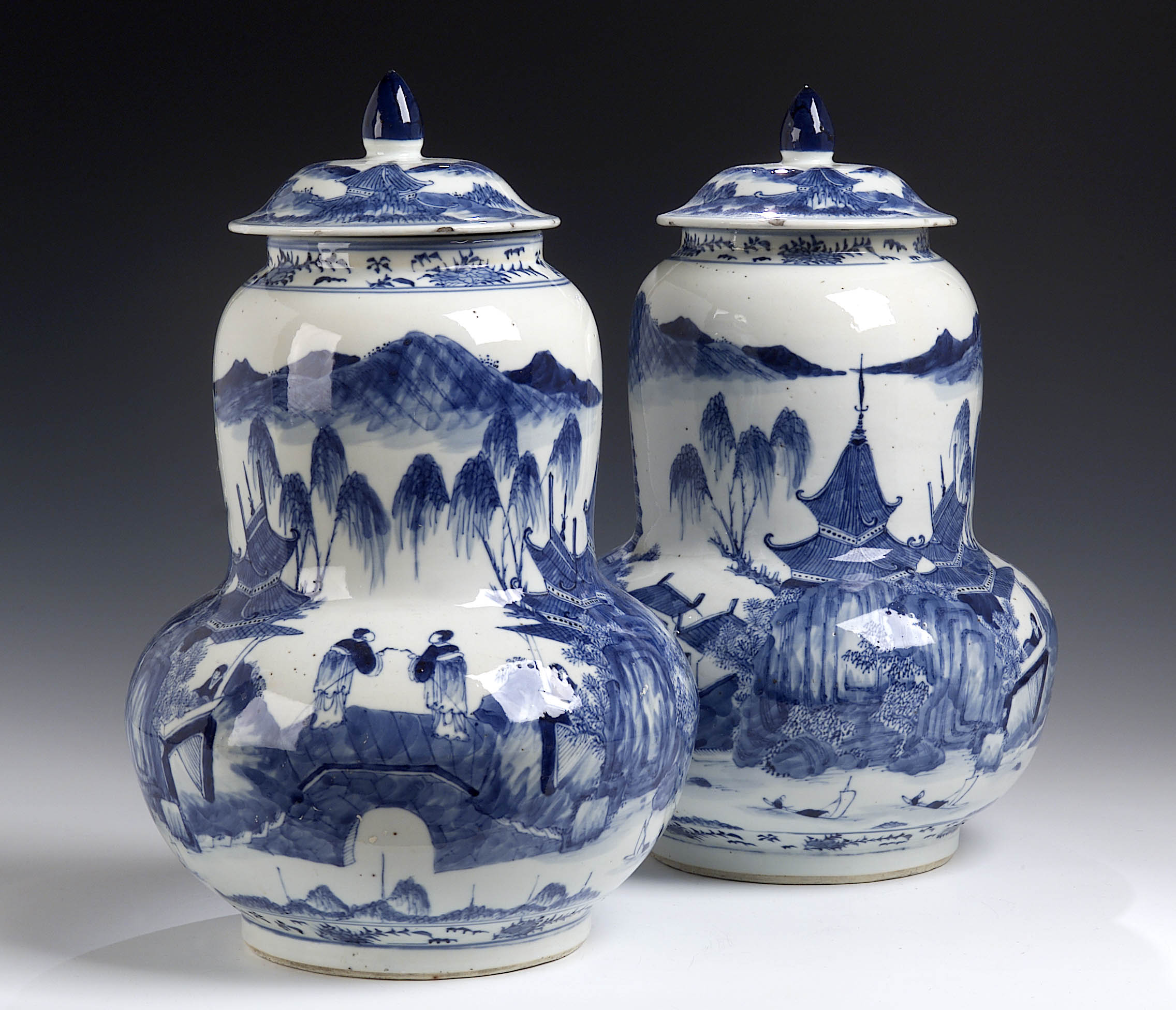 A pair of 19th century Chinese gourd shaped blue painted vases and covers