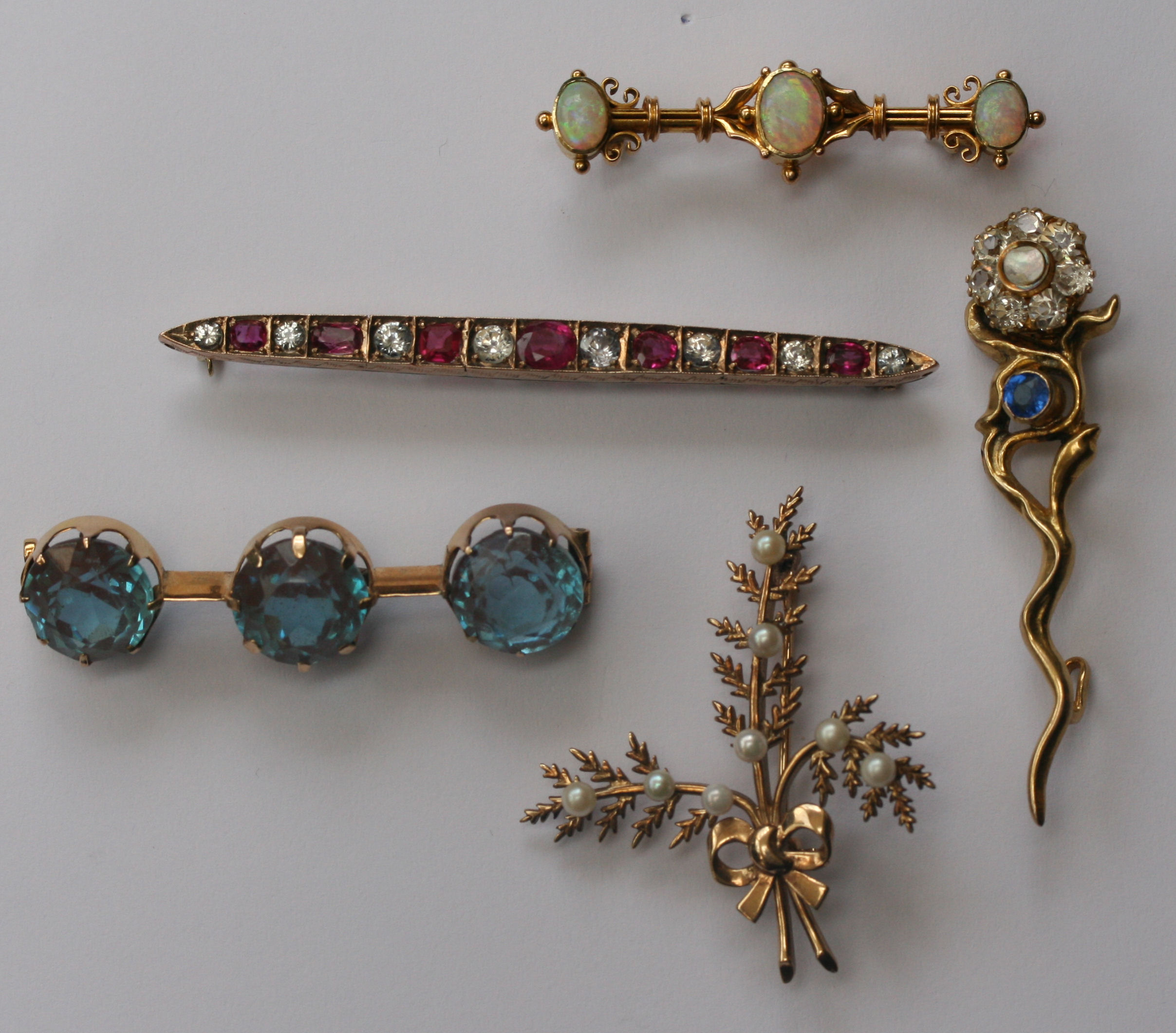 A group of five gold, opal, pearl and gem set brooches