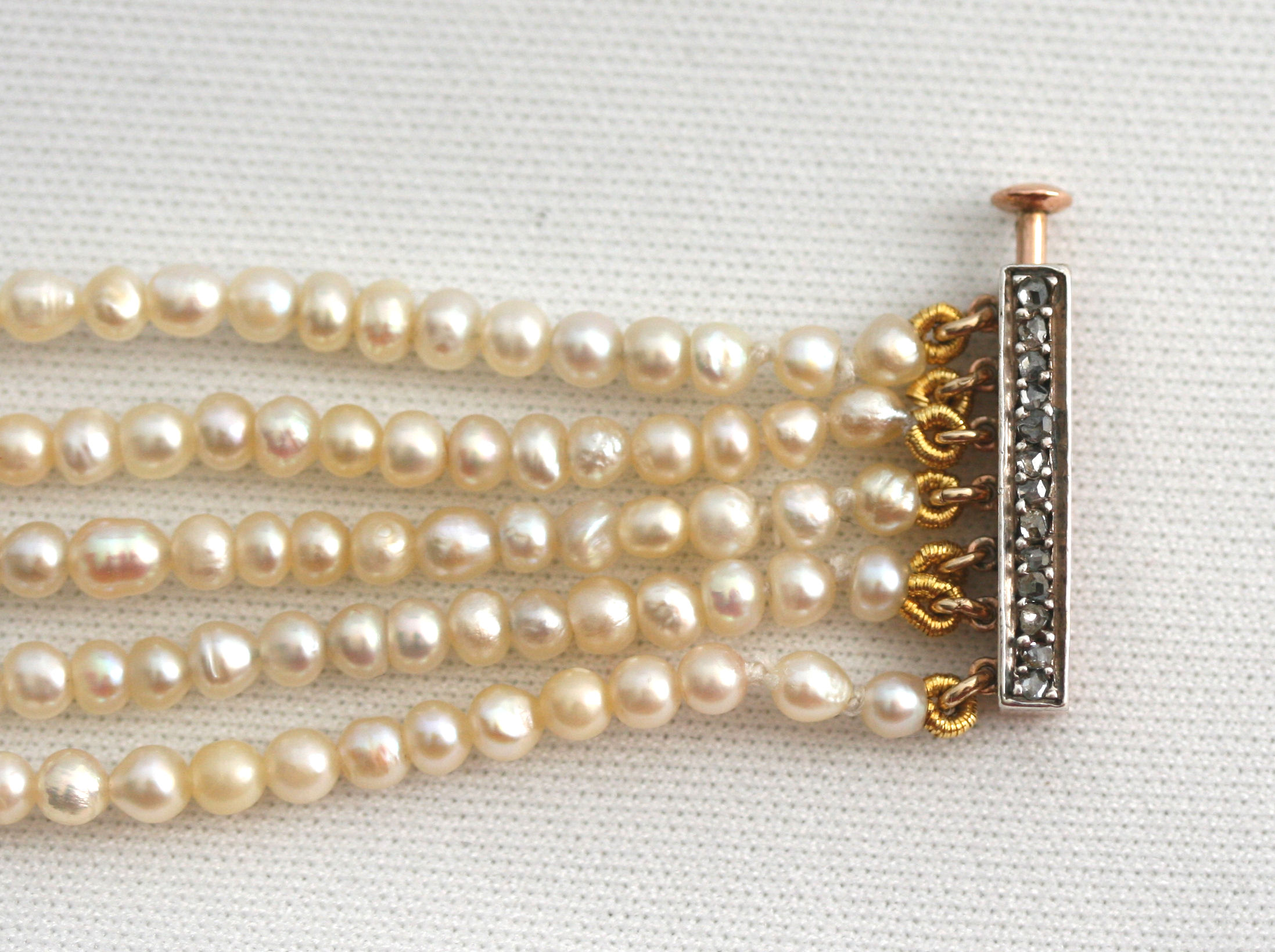 An early 20th century five-row bracelet with diamond set clasp,