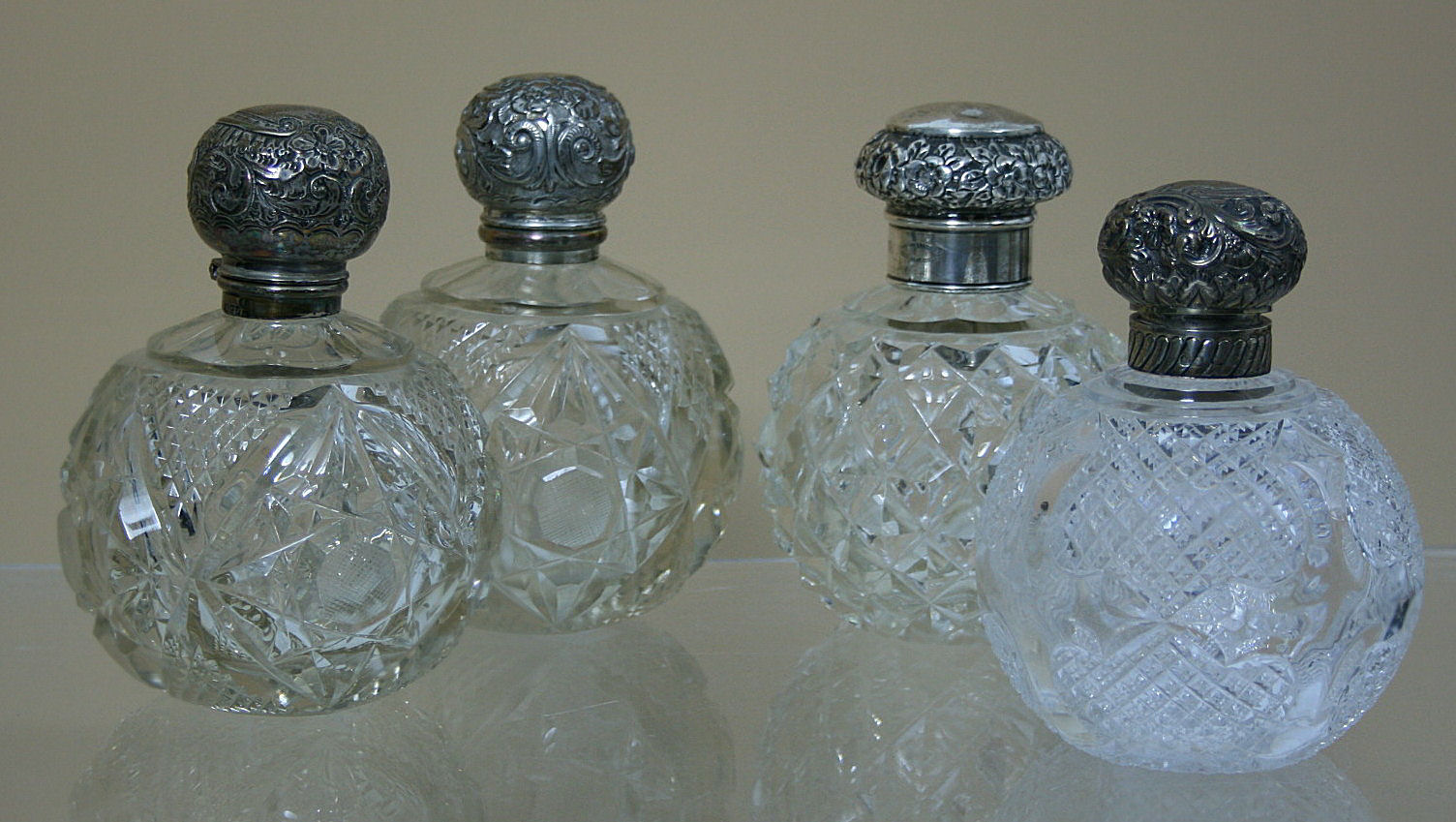 A near pair of silver mounted table perfume jars and covers