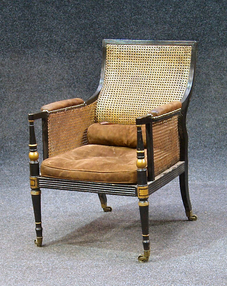 A Regency ebonised bergere armchair,