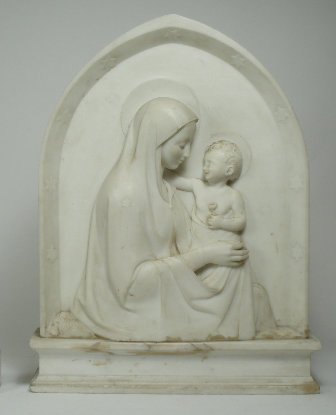 A marble relief sculpture of the Madonna and Child