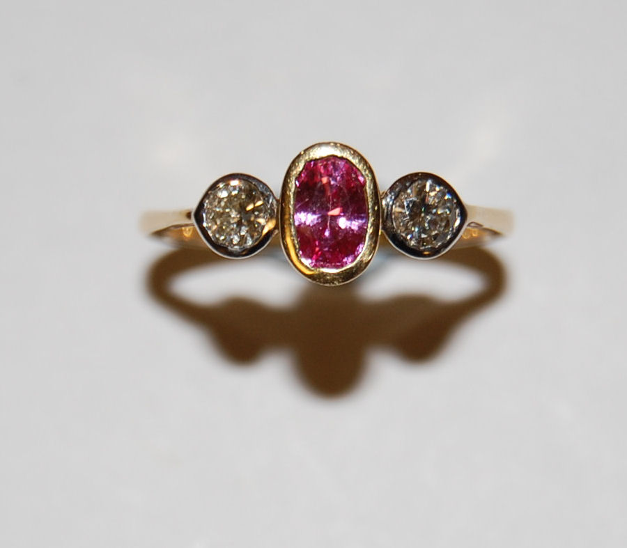 A three stone pink sapphire and diamond ring