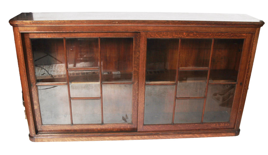 A late 19th/ early 20th century large low oak glazed bookcase