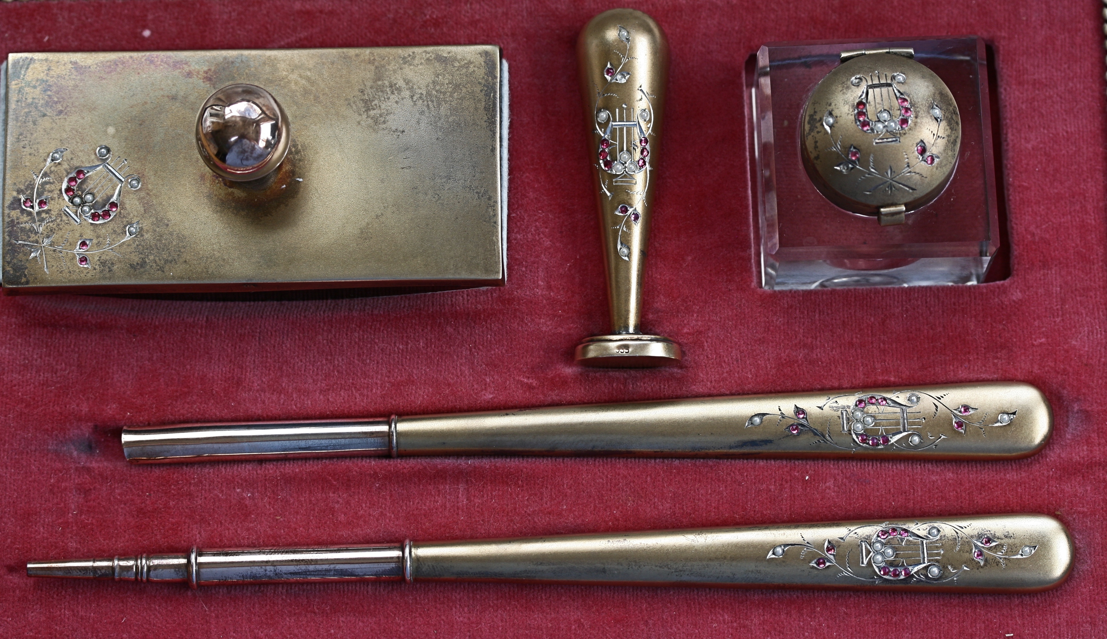 A cased silver gilt and gem set desk set