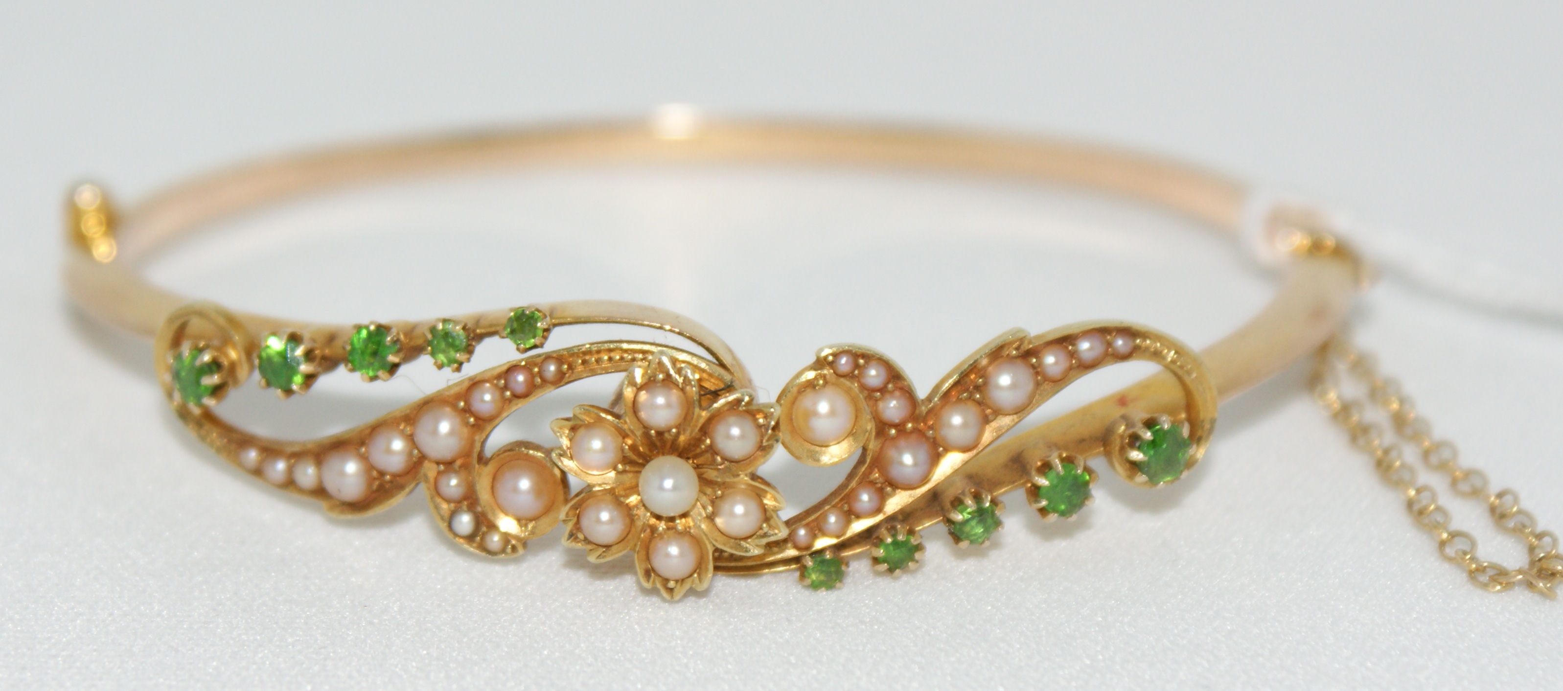 An Edwardian gold, pearl and gem set bangle