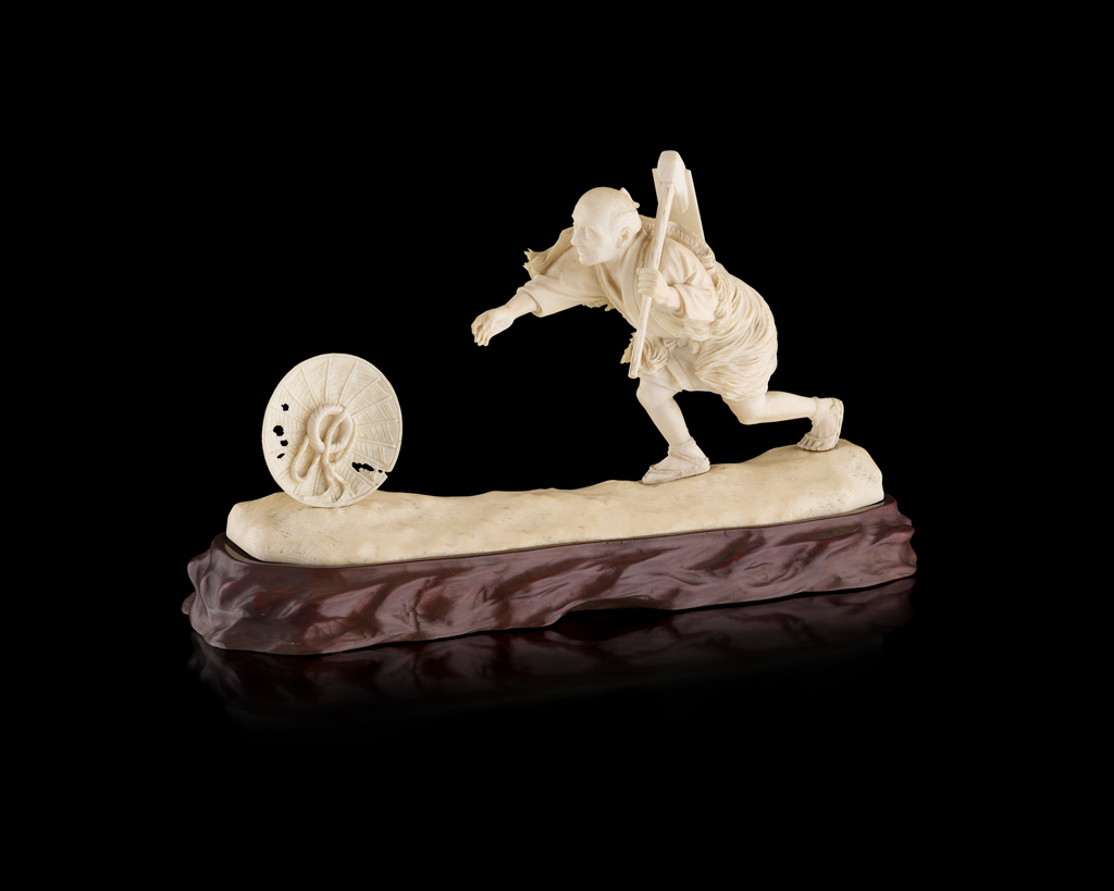 IVORY OKIMONO OF A FARMER CHASING A HAT
