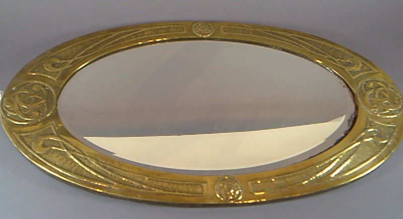 An Arts and Crafts brass framed mirror