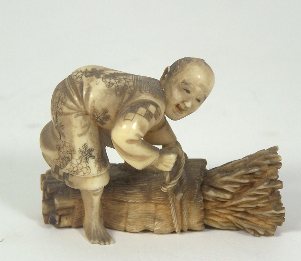 A Japanese ivory okimono of a wood collector, Meiji period