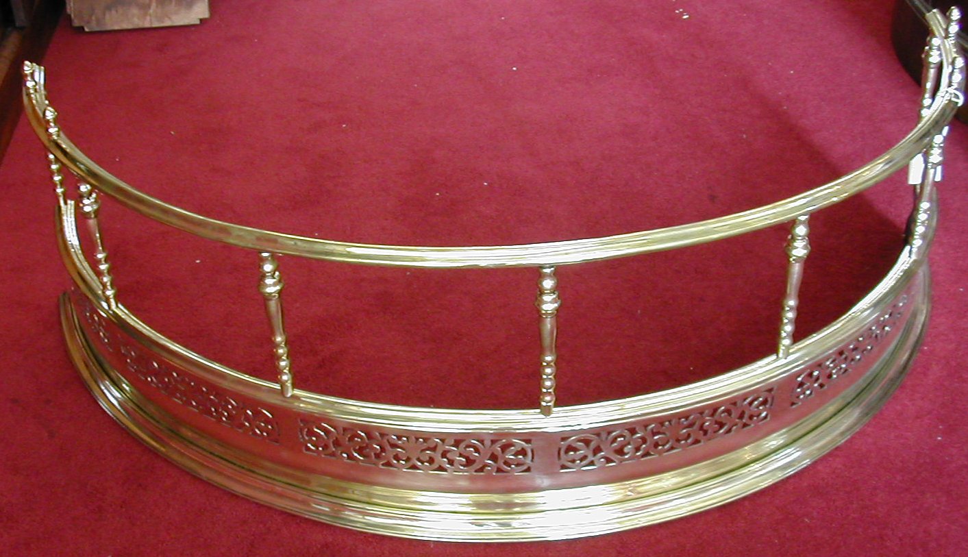 A Victorian brass demi-lune fender,