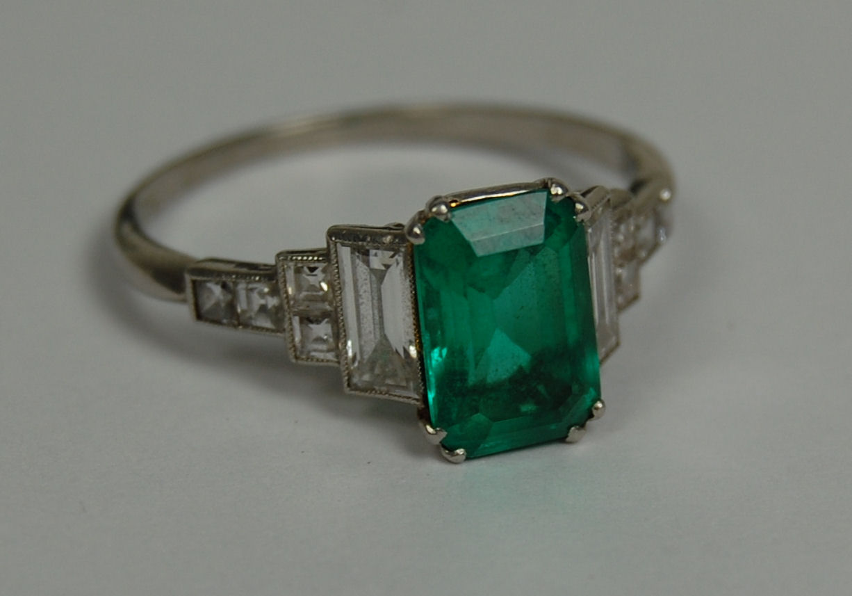 An Art Deco platinum mounted emerald and diamond set ring