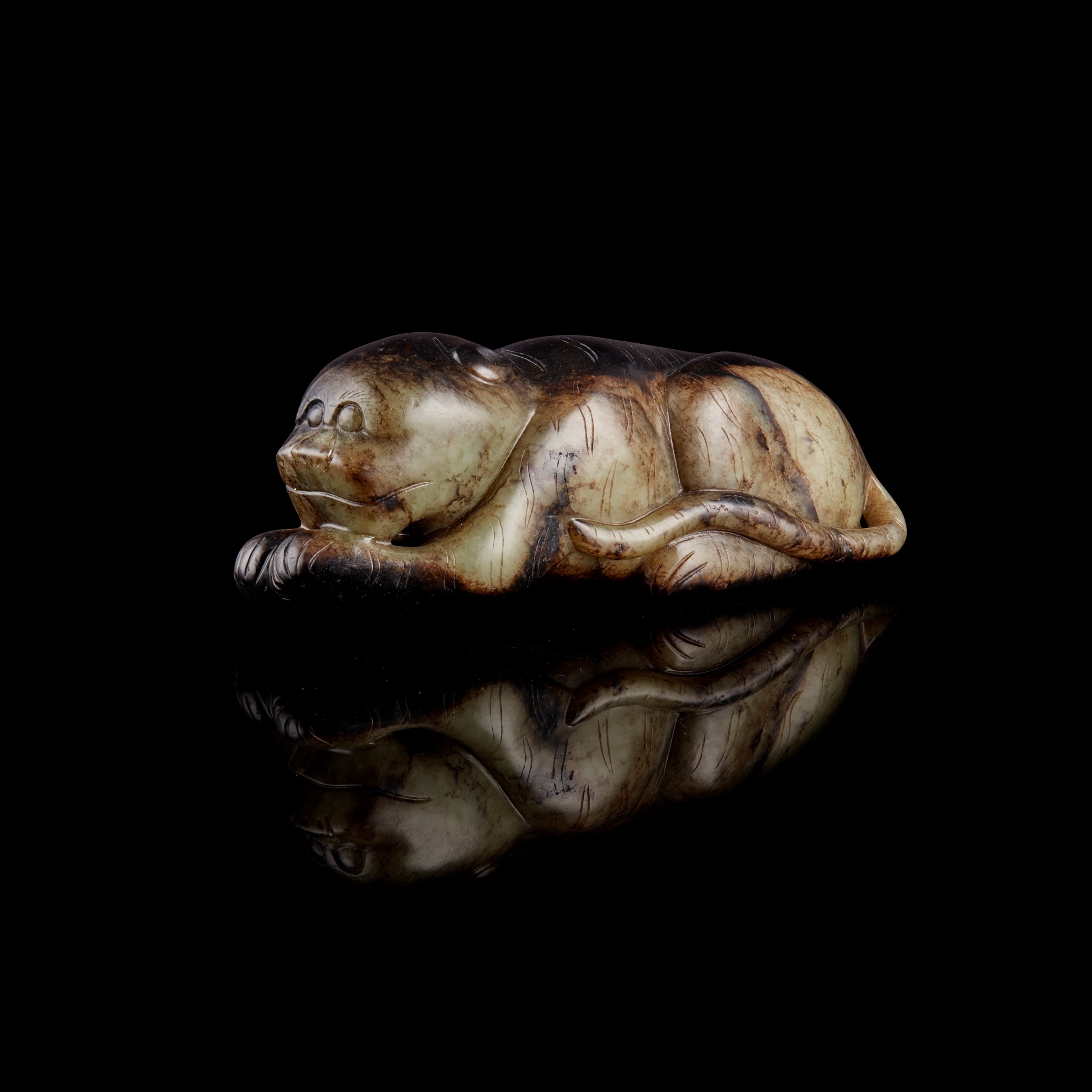 CELADON JADE WITH DARK SKIN CARVING OF A TIGER