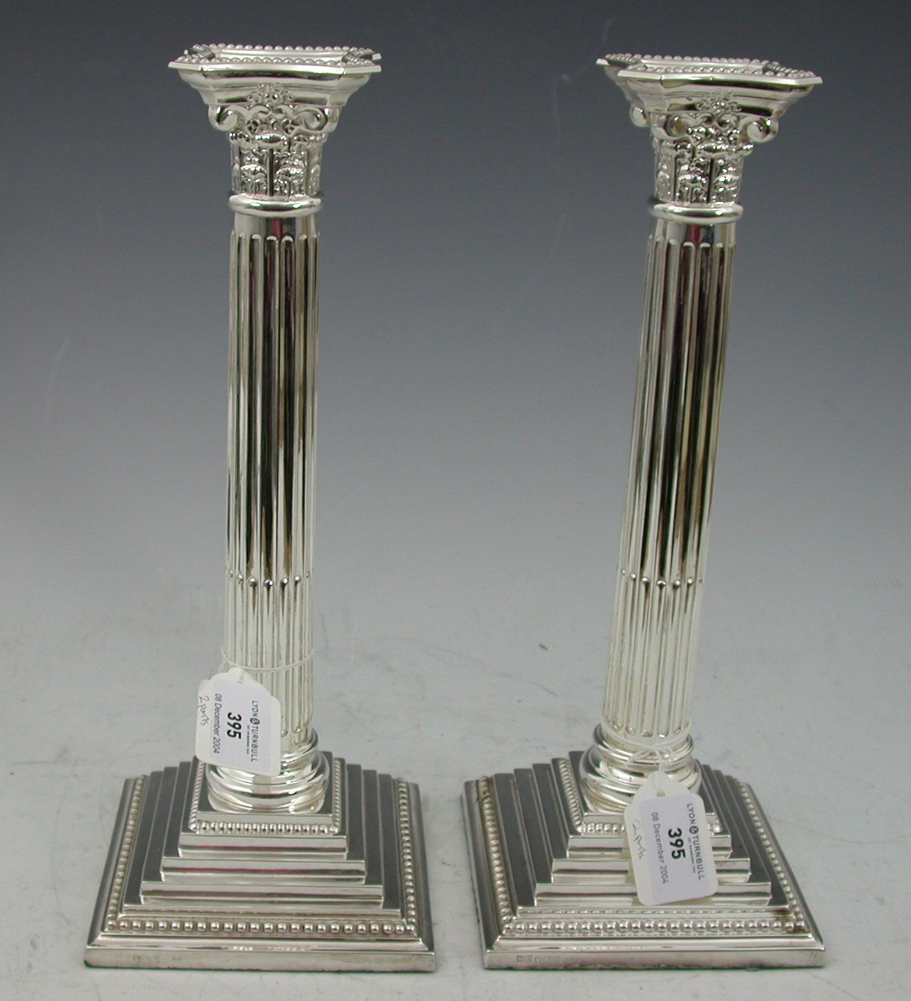 A pair of contemporary corinthian column candlesticks,