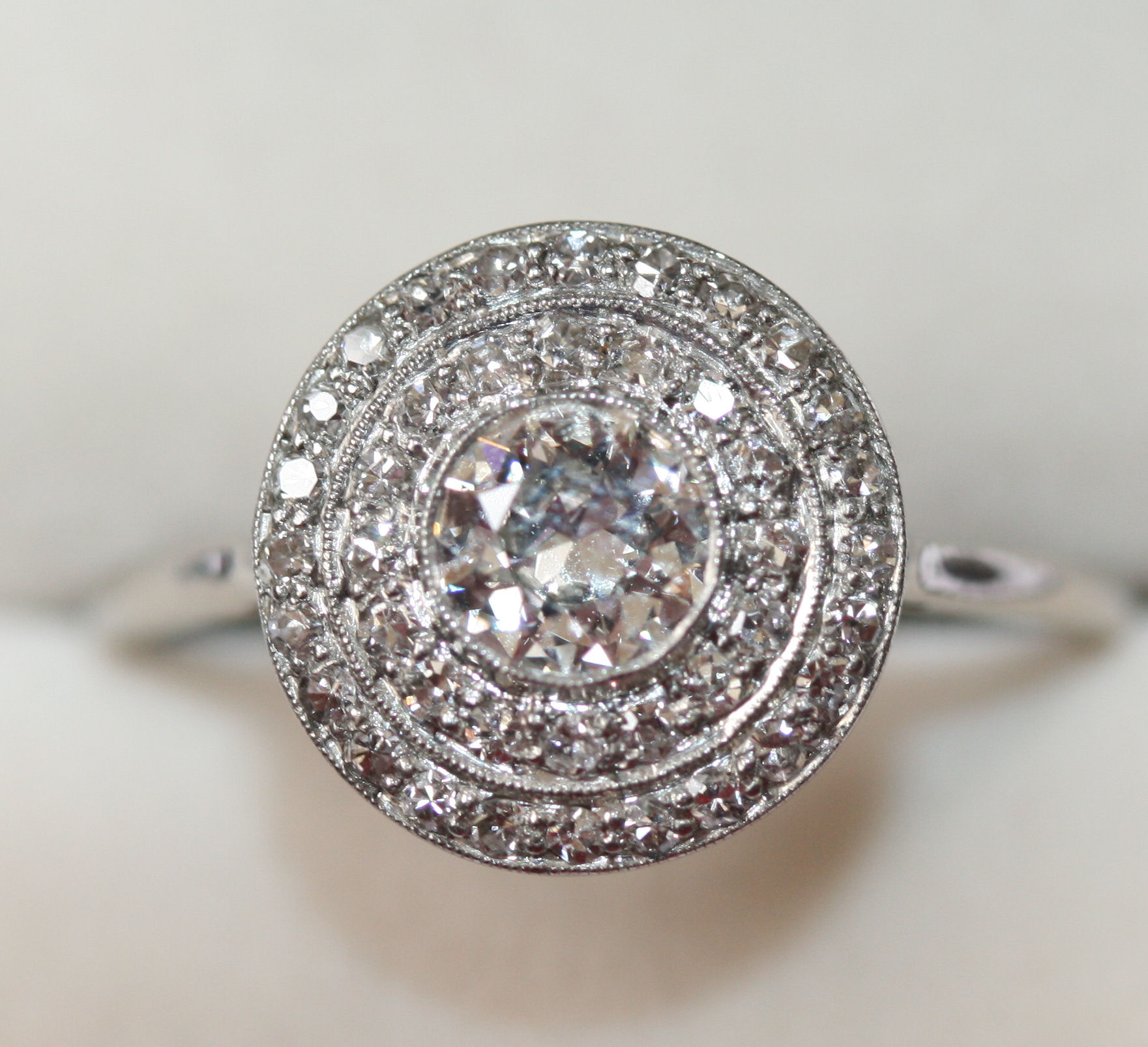 An early 20th century platinum mounted diamond circular target cluster ring