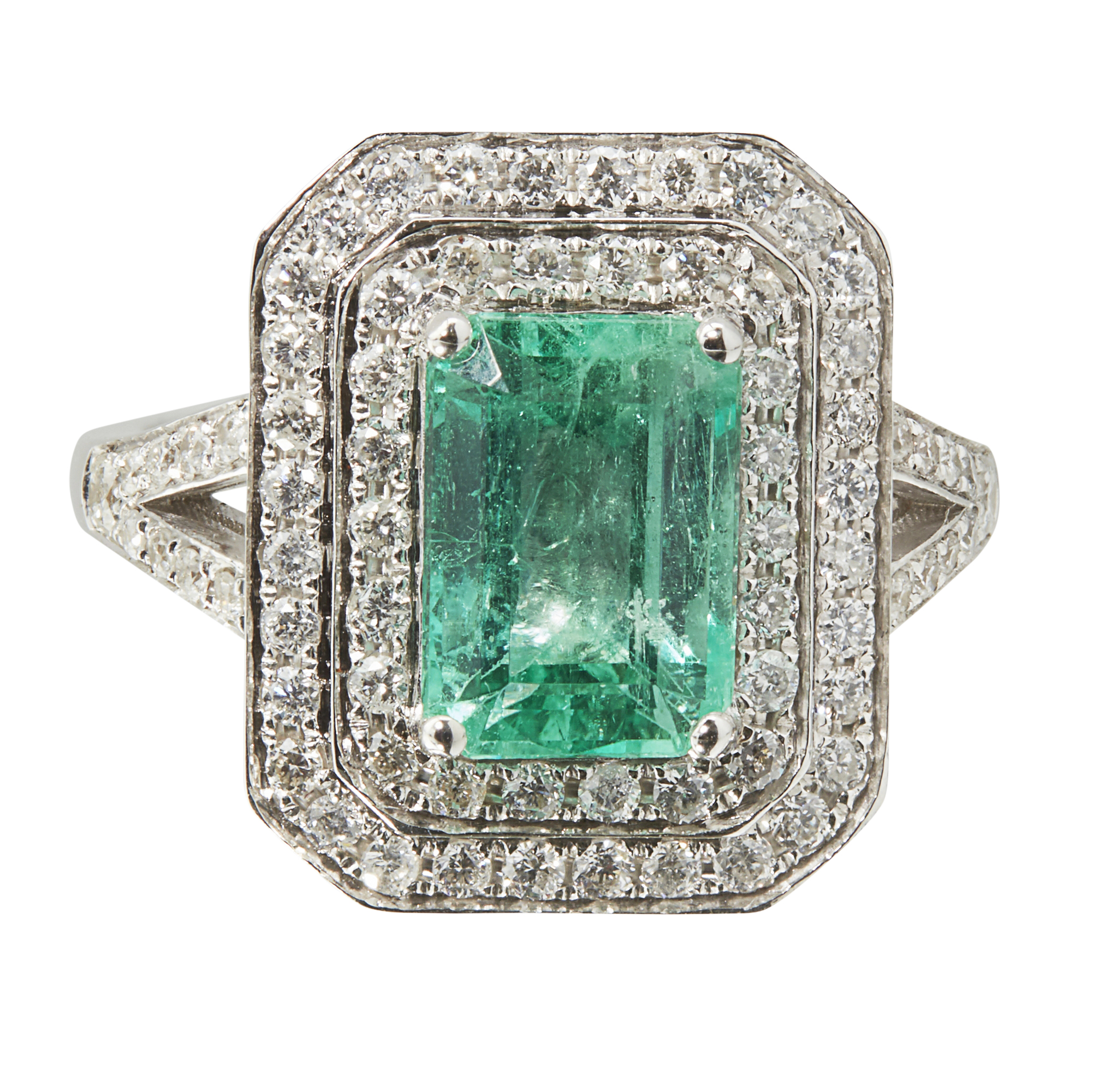 An emerald and diamond cluster ring