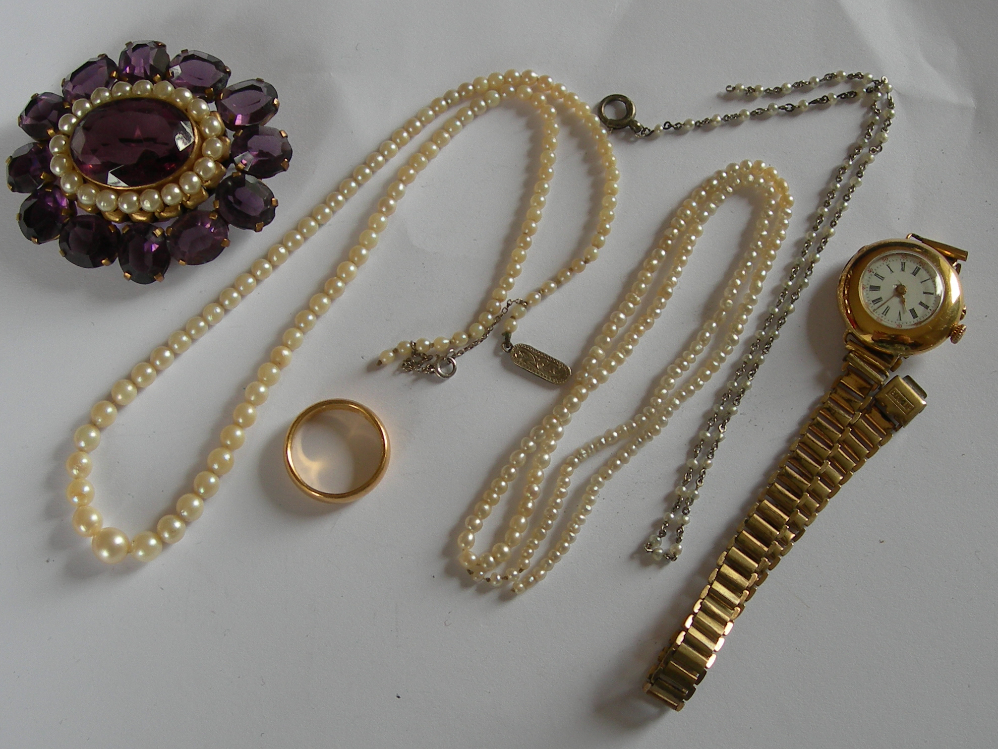 A large purple paste and simulated pearl set brooch,