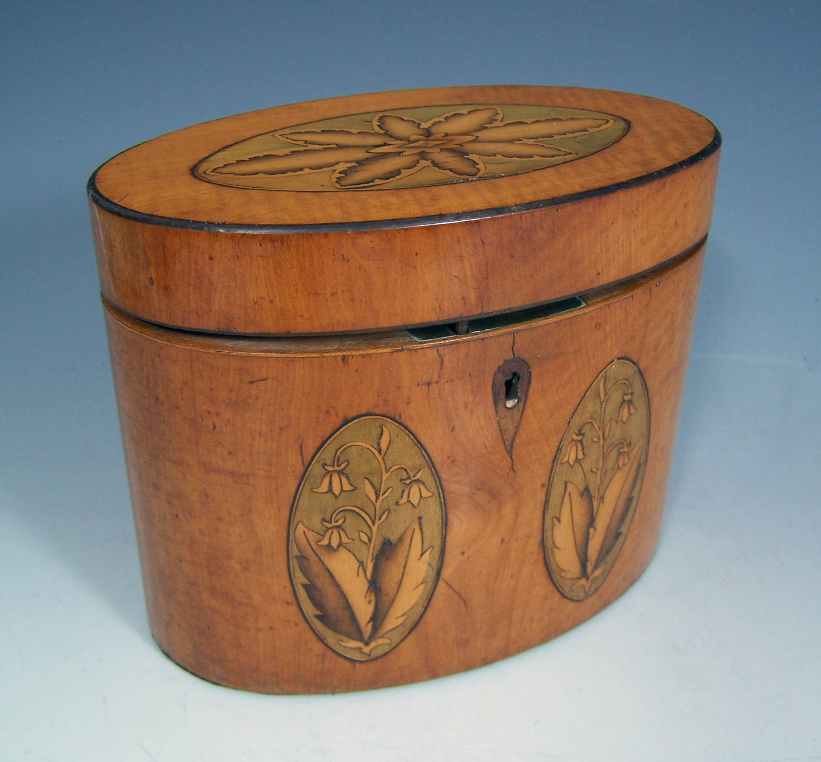 A George III period satinwood and harewood elliptical tea caddy