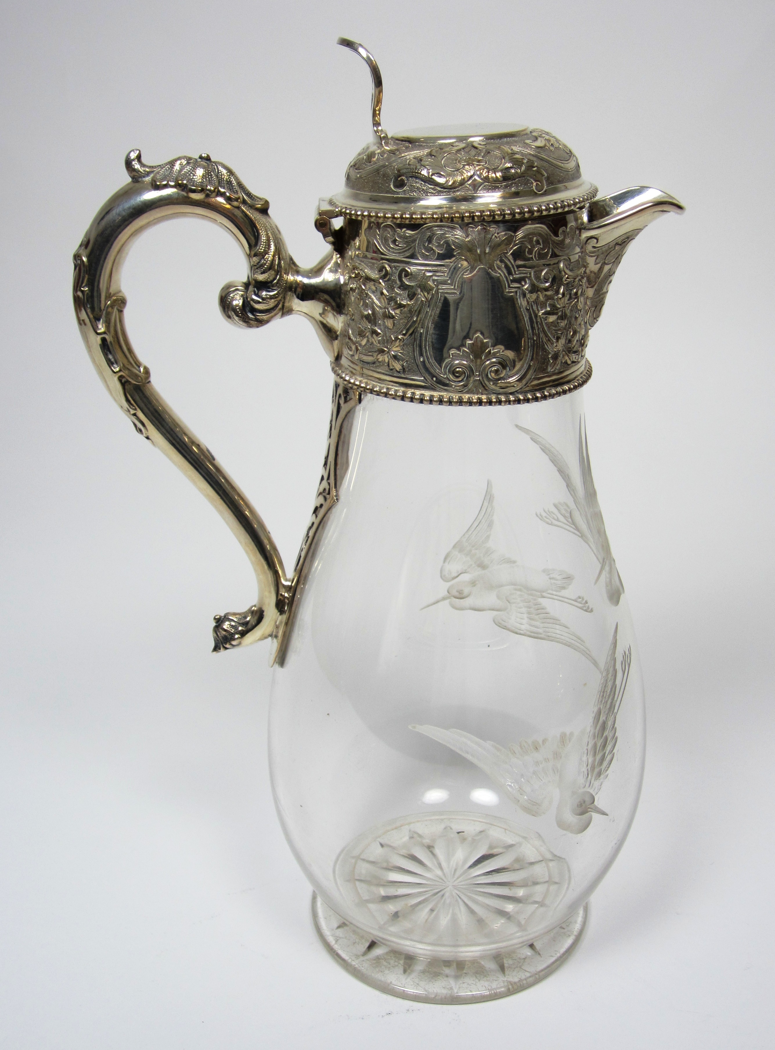 A late Victorian silver plated and engraved glass claret jug
