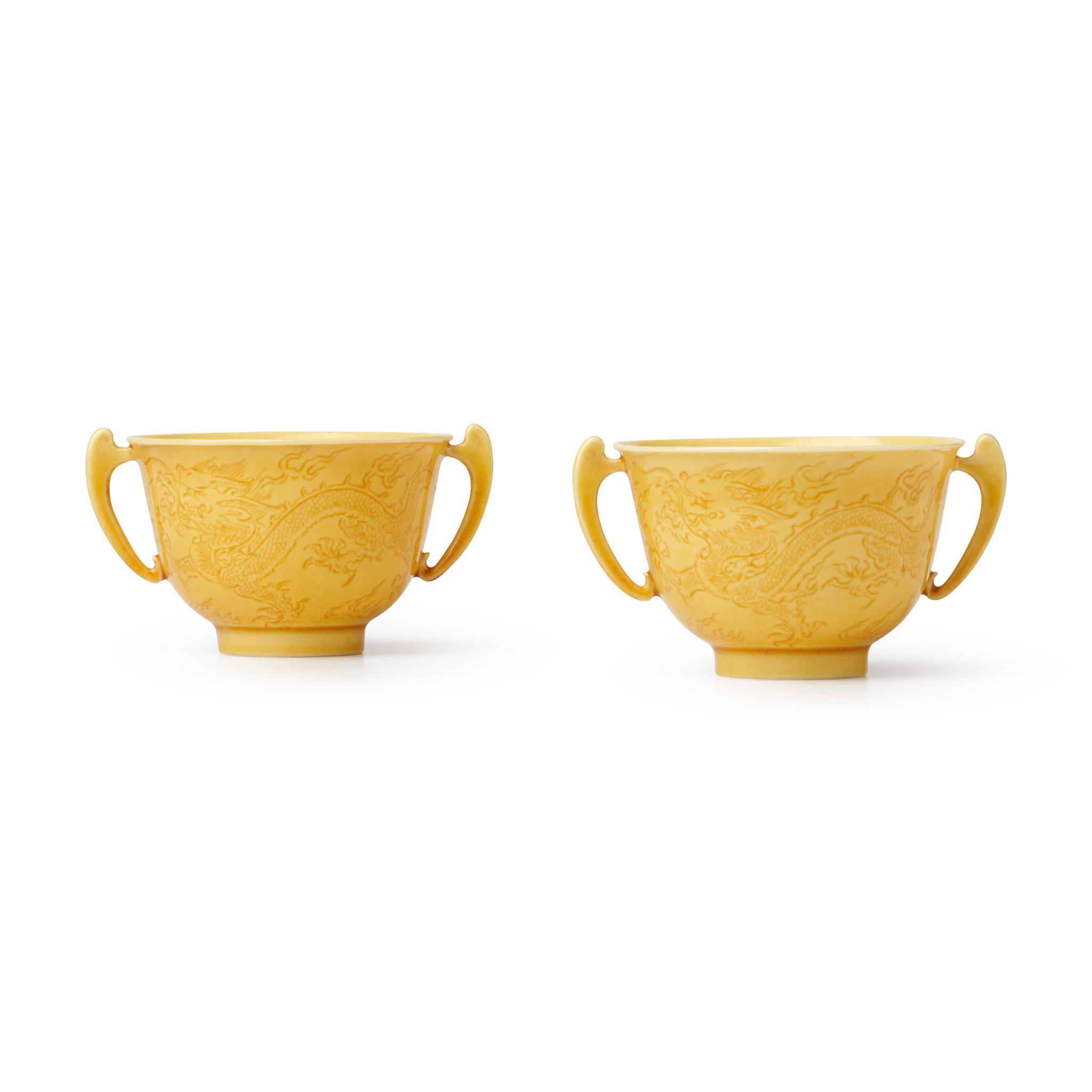 TWO CHINESE YELLOW-GLAZED INCISED 'DRAGON' HANDLED CUPS