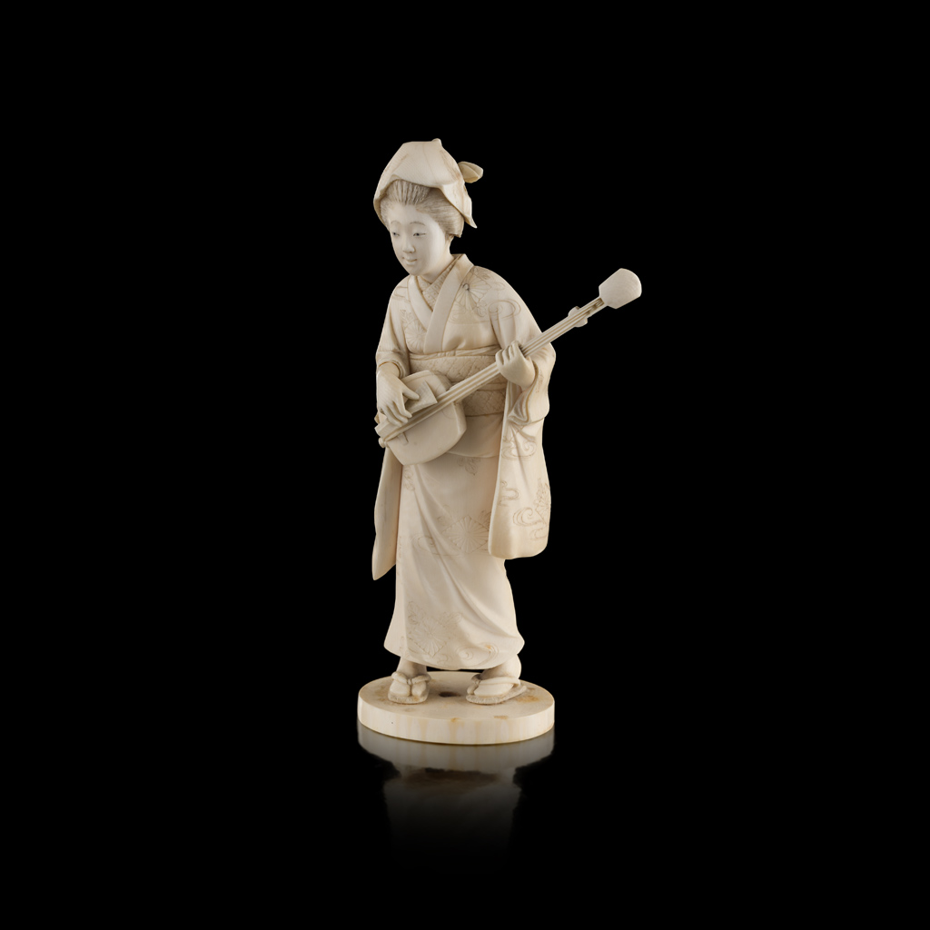 CARVED IVORY OKIMONO OF A LADY PLAYING A SHAMISEN