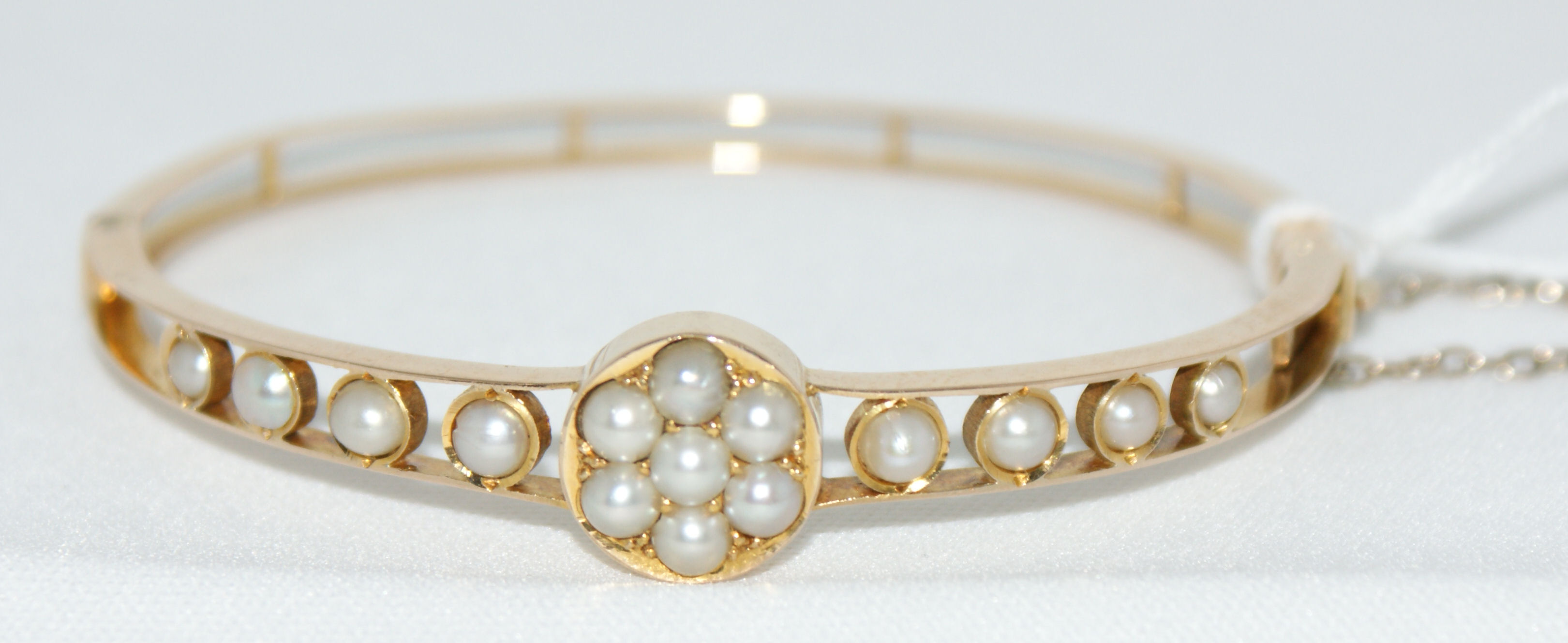An Edwardian hinged pearl set bangle