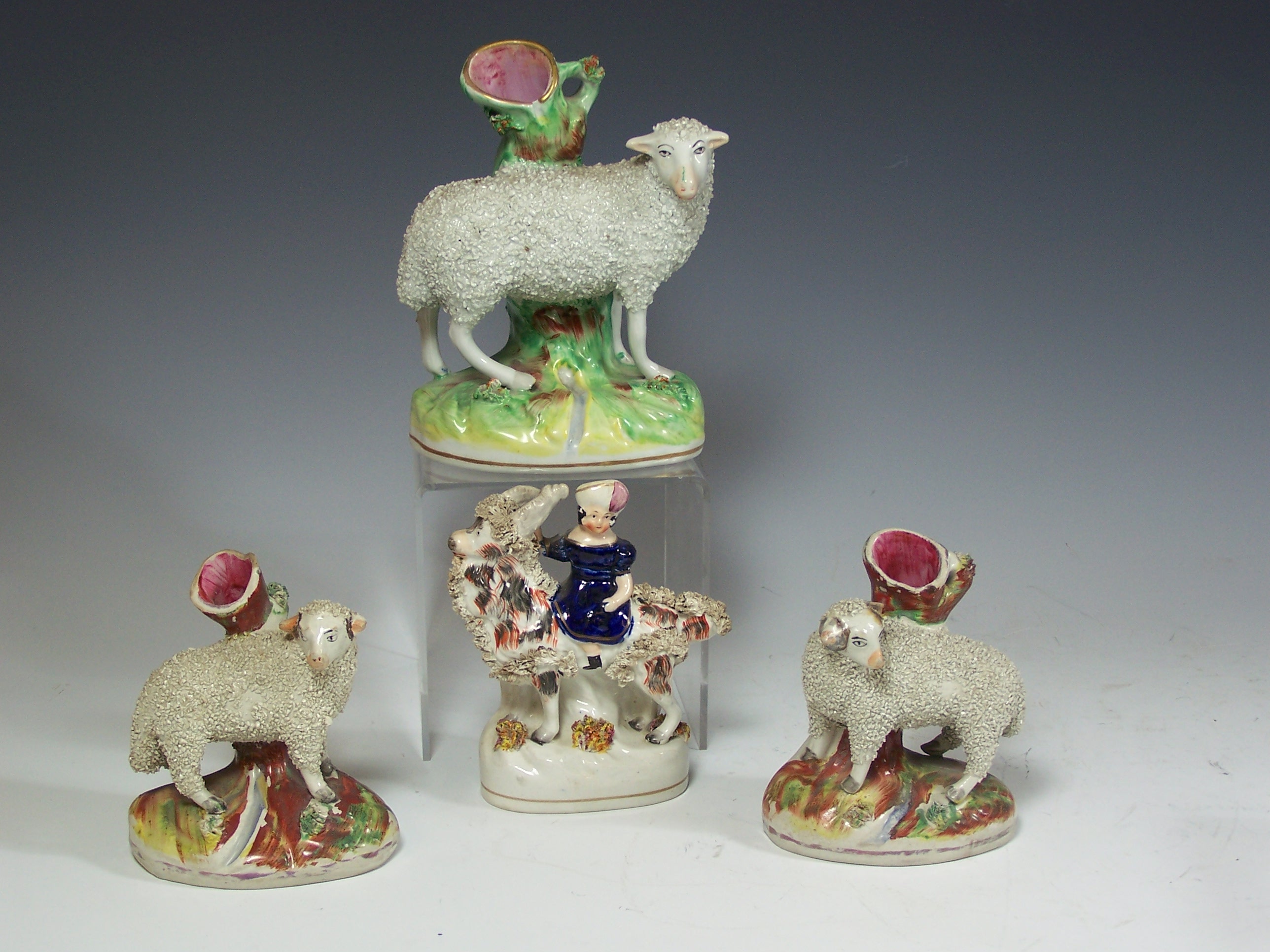 A group of three Staffordshire sheep spill vases