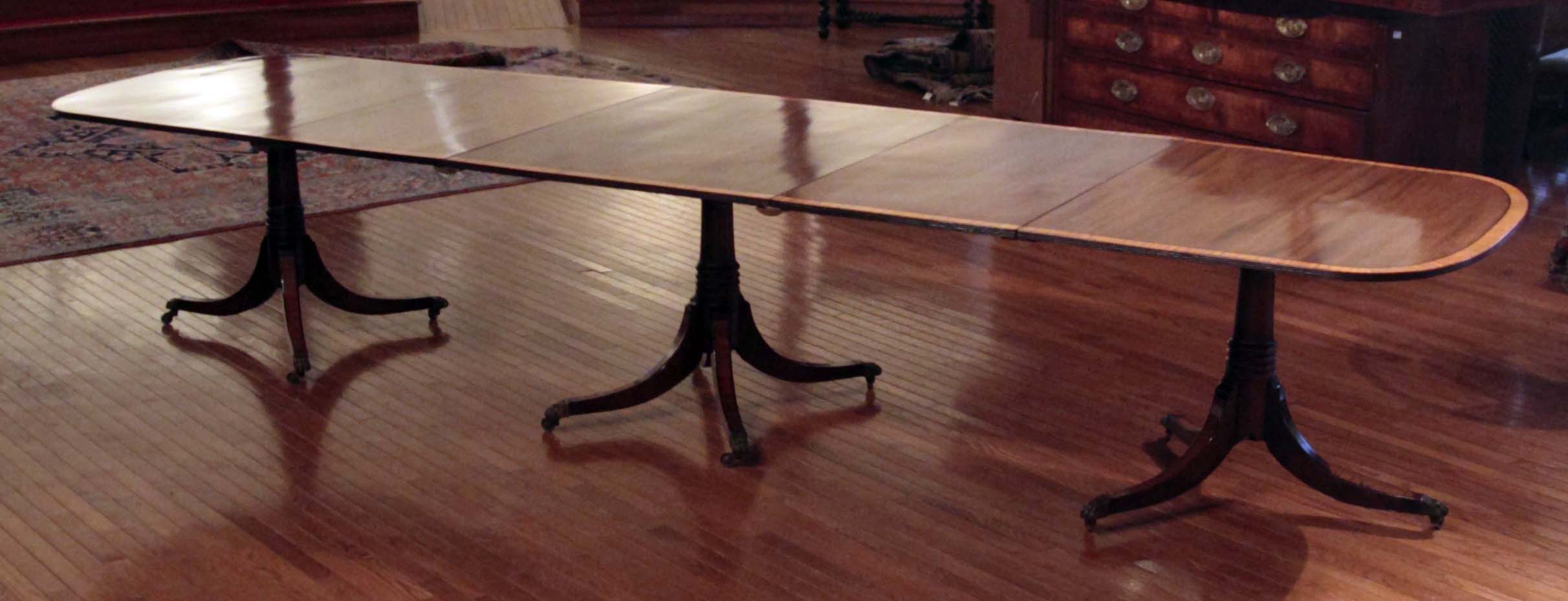 A 19th century mahogany and satinwood crossbanded three pillar dining table