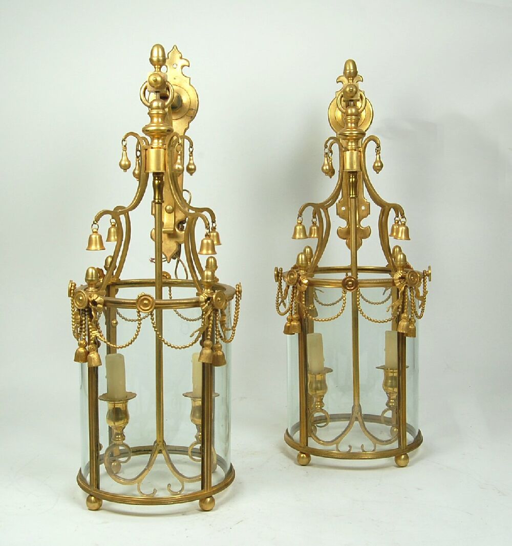 A unusual pair of gilt metal wall mounted hall lanterns, circa 1900