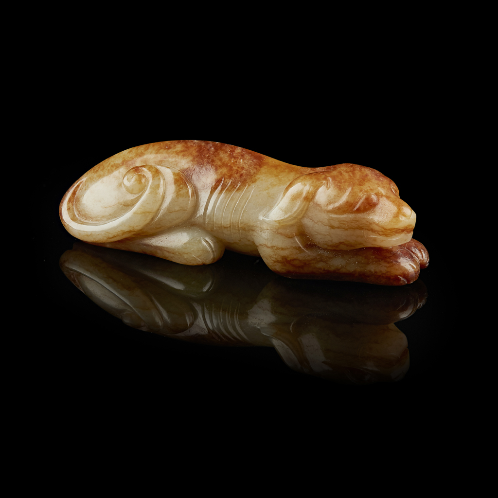 CELADON AND RUSSET JADE CARVING OF A HOUND