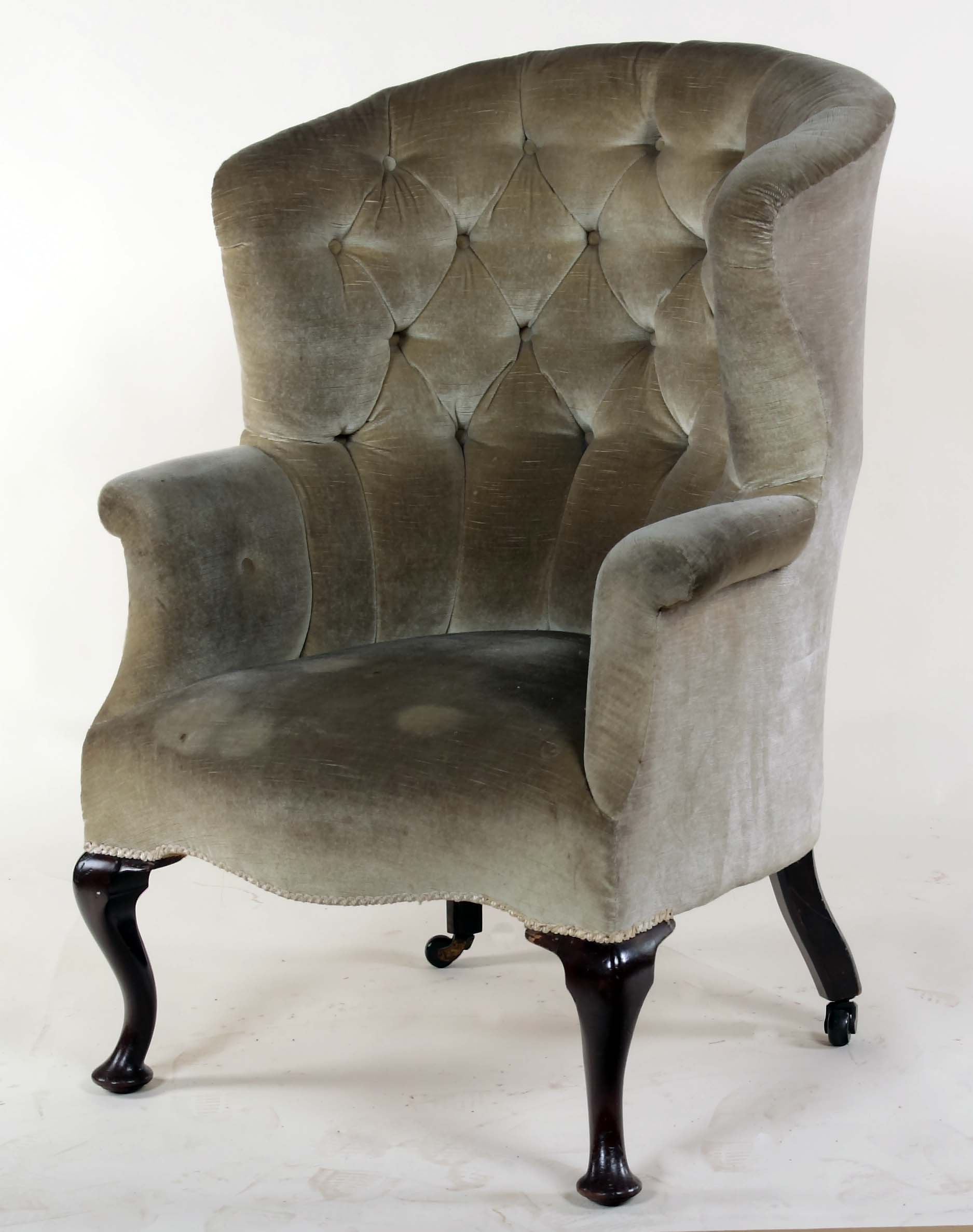 An early 19th century mahogany framed wing armchair