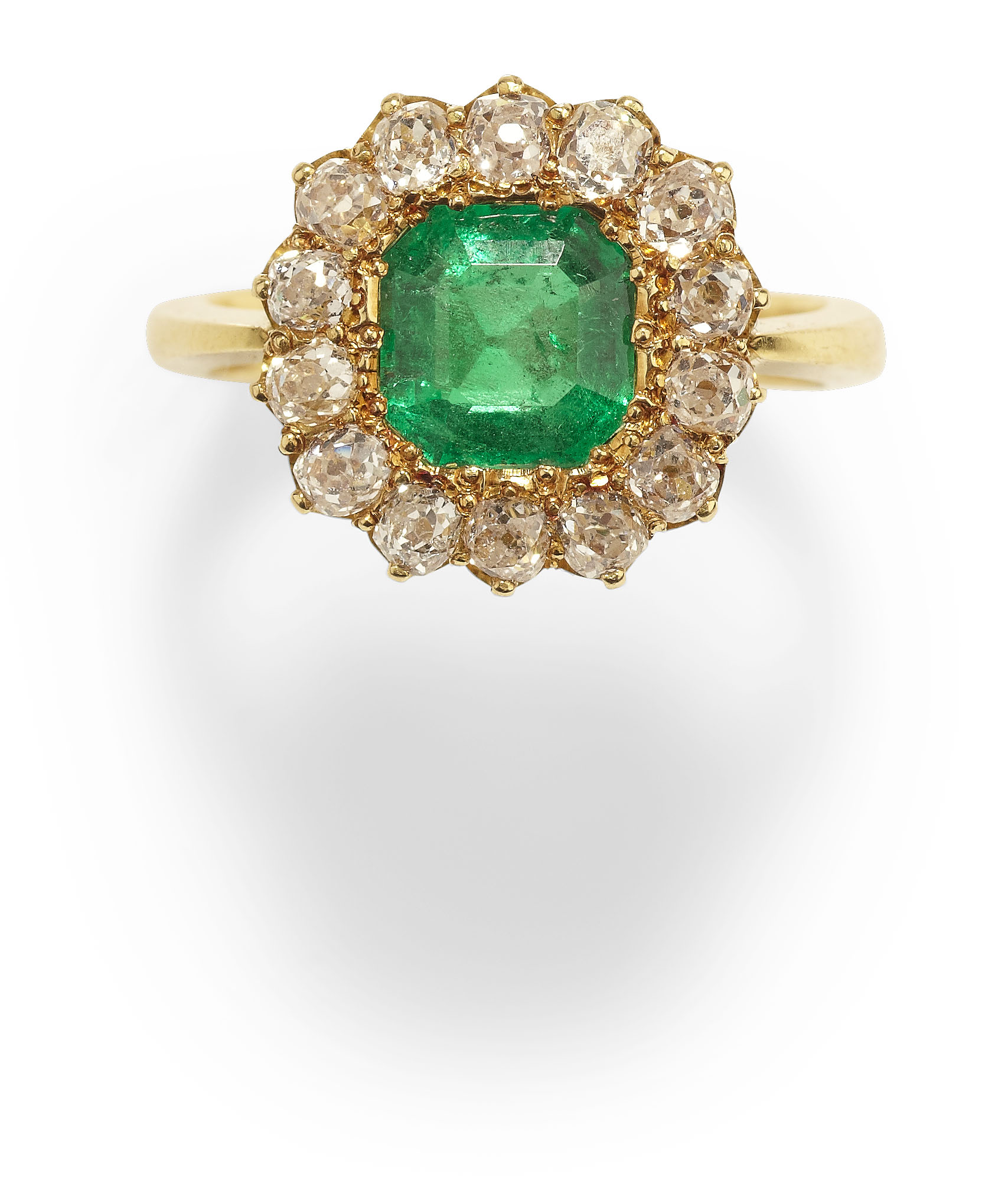 An 18ct gold mounted emerald and diamond cluster ring,
