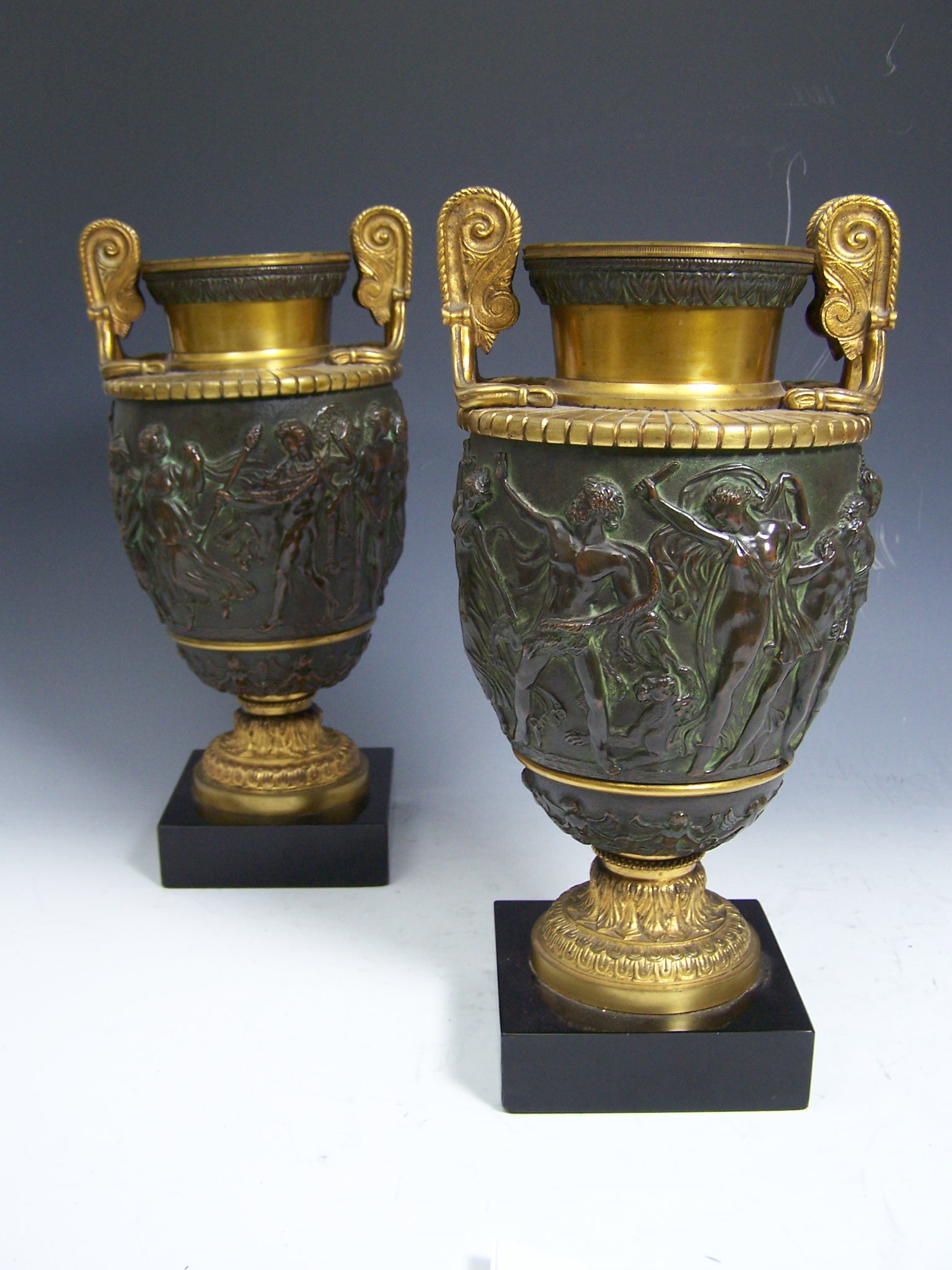 A pair of bronze patinated and giltmetal urns After the Antique