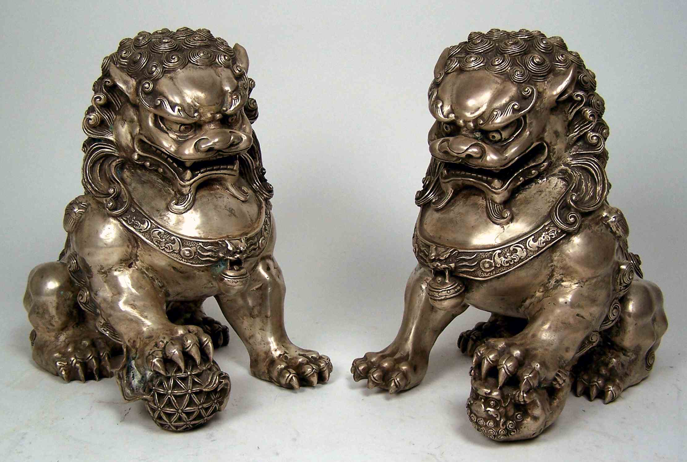 A pair of 20th century Chinese white metal lion dogs