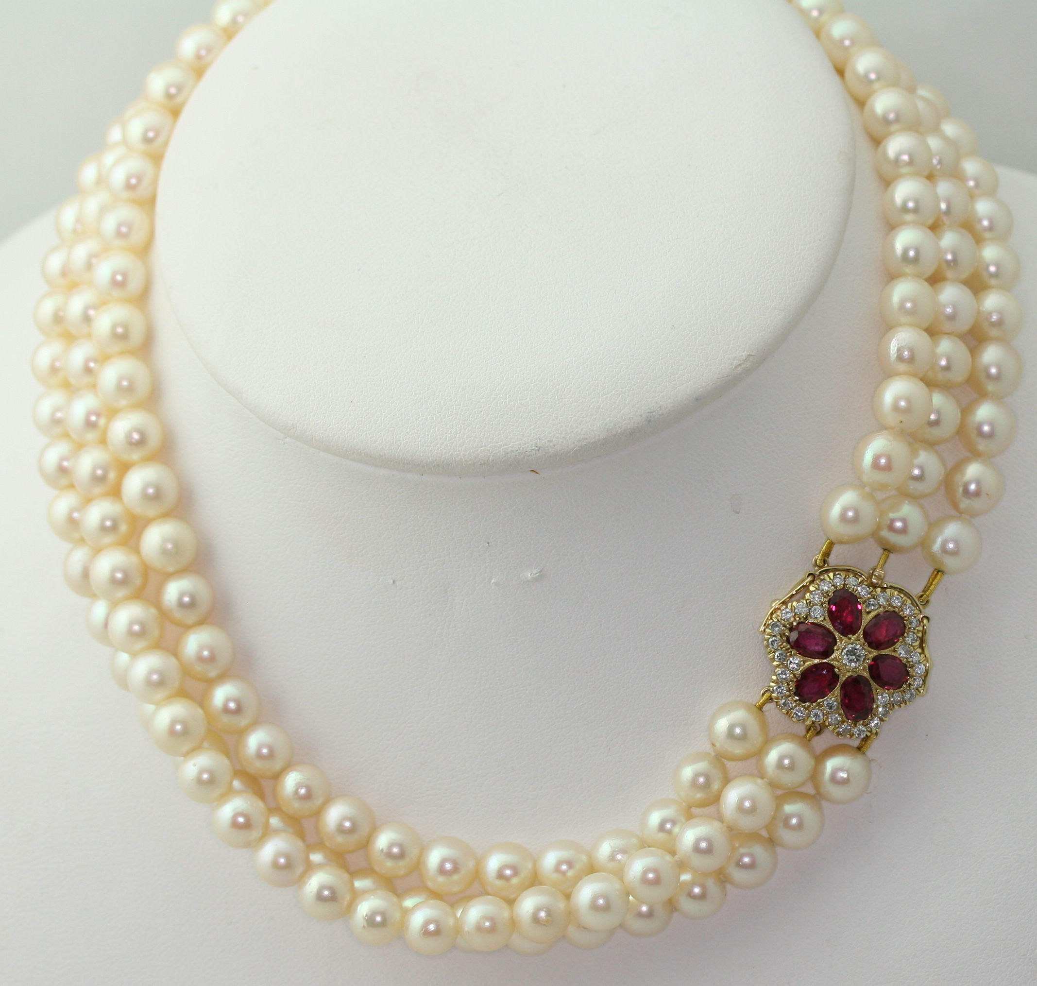 A cultured pearl three-row necklace with ruby and diamond set clasp