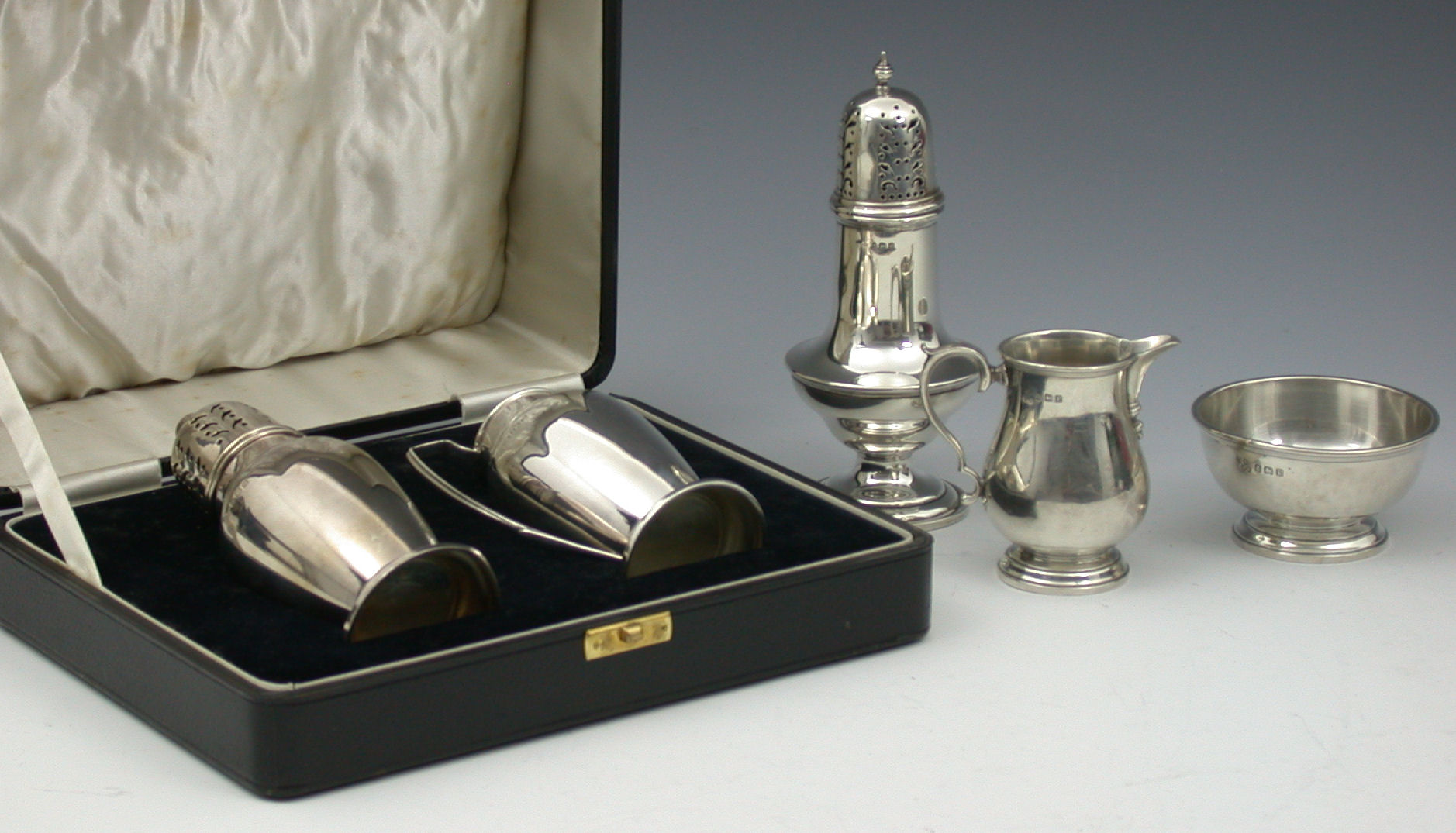 A sugar caster and matching cream jug,