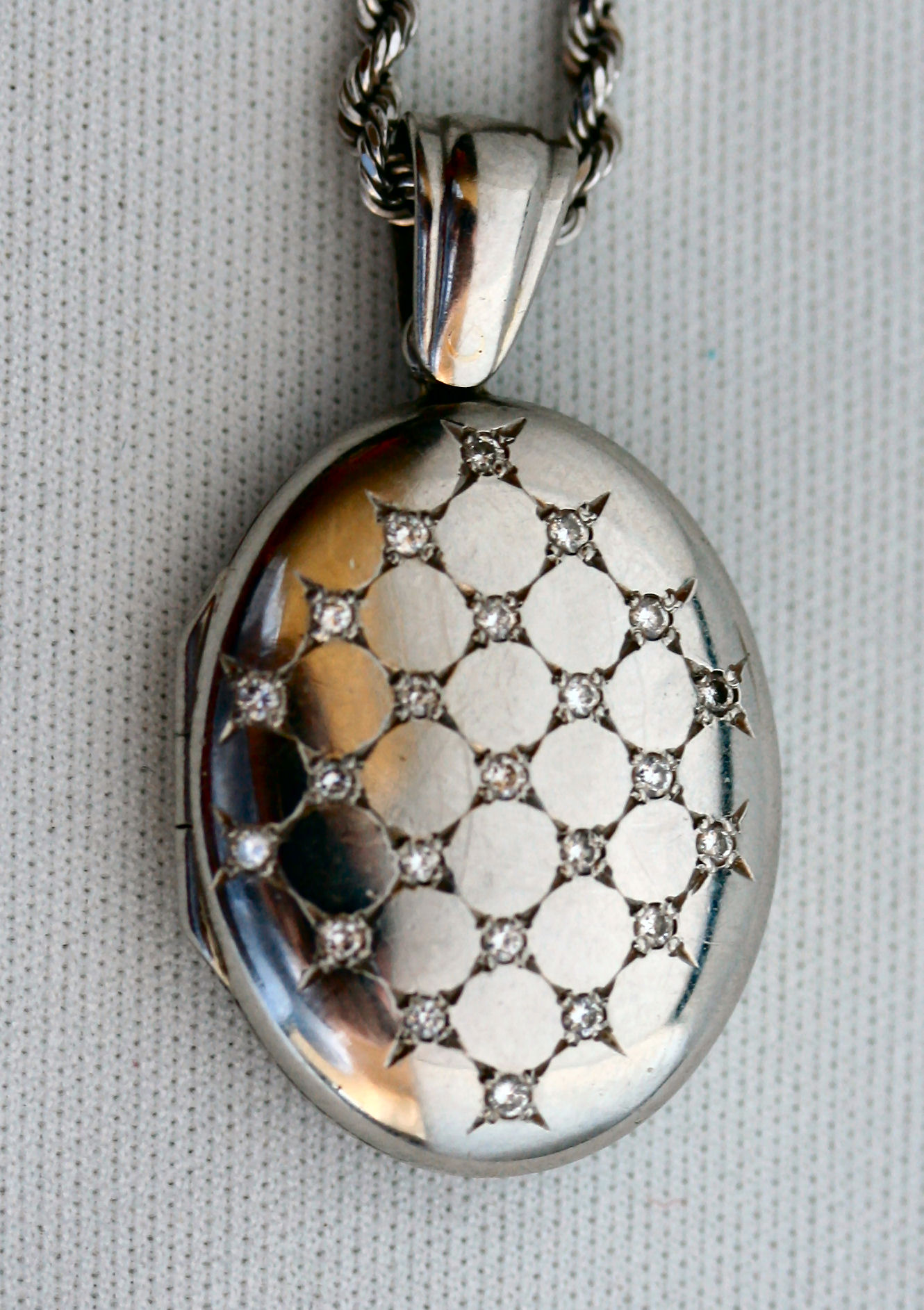 A platinum mounted diamond set locket with chain,