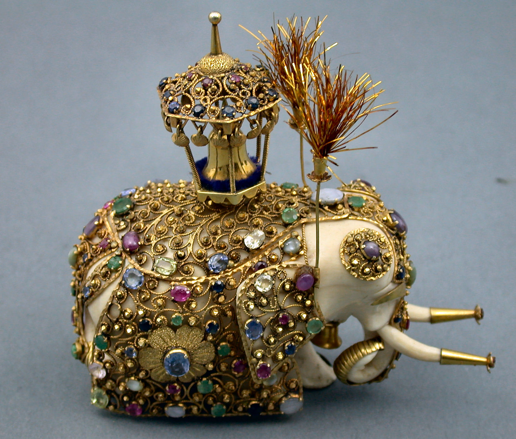 A multi-gem caparisoned carved ivory elephant,