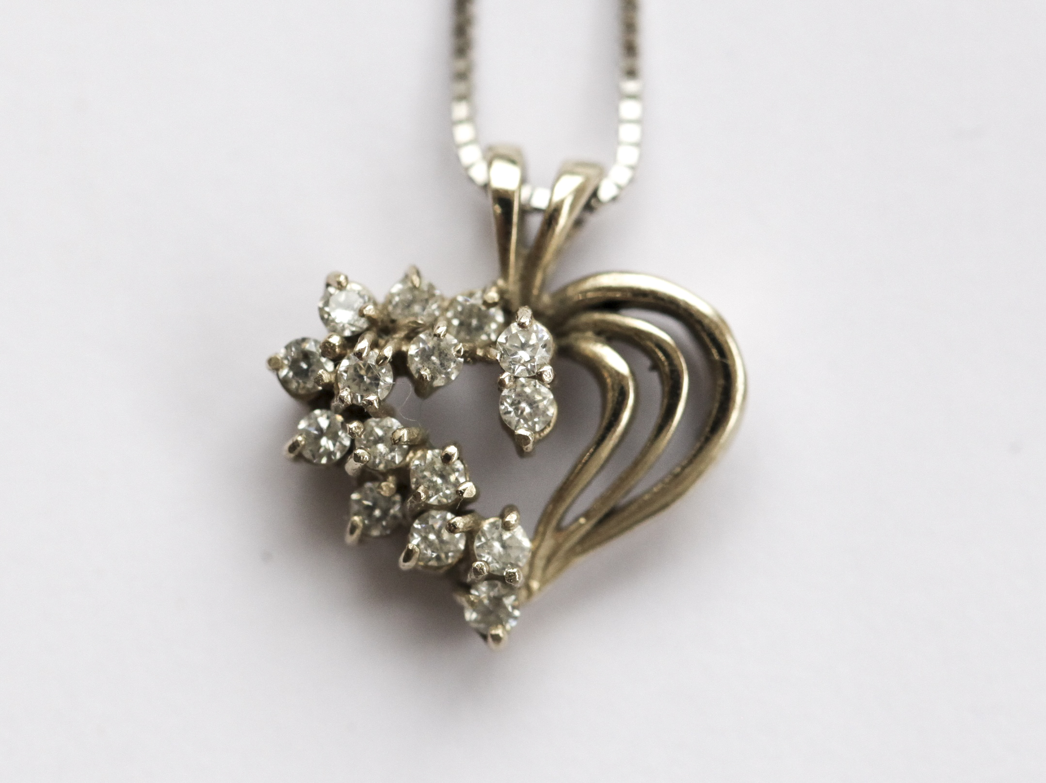 A collection of three rings and a pendant and chain