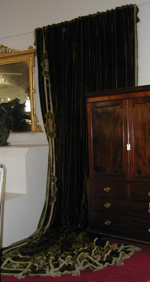 A large pair of green velvet embroidered curtains