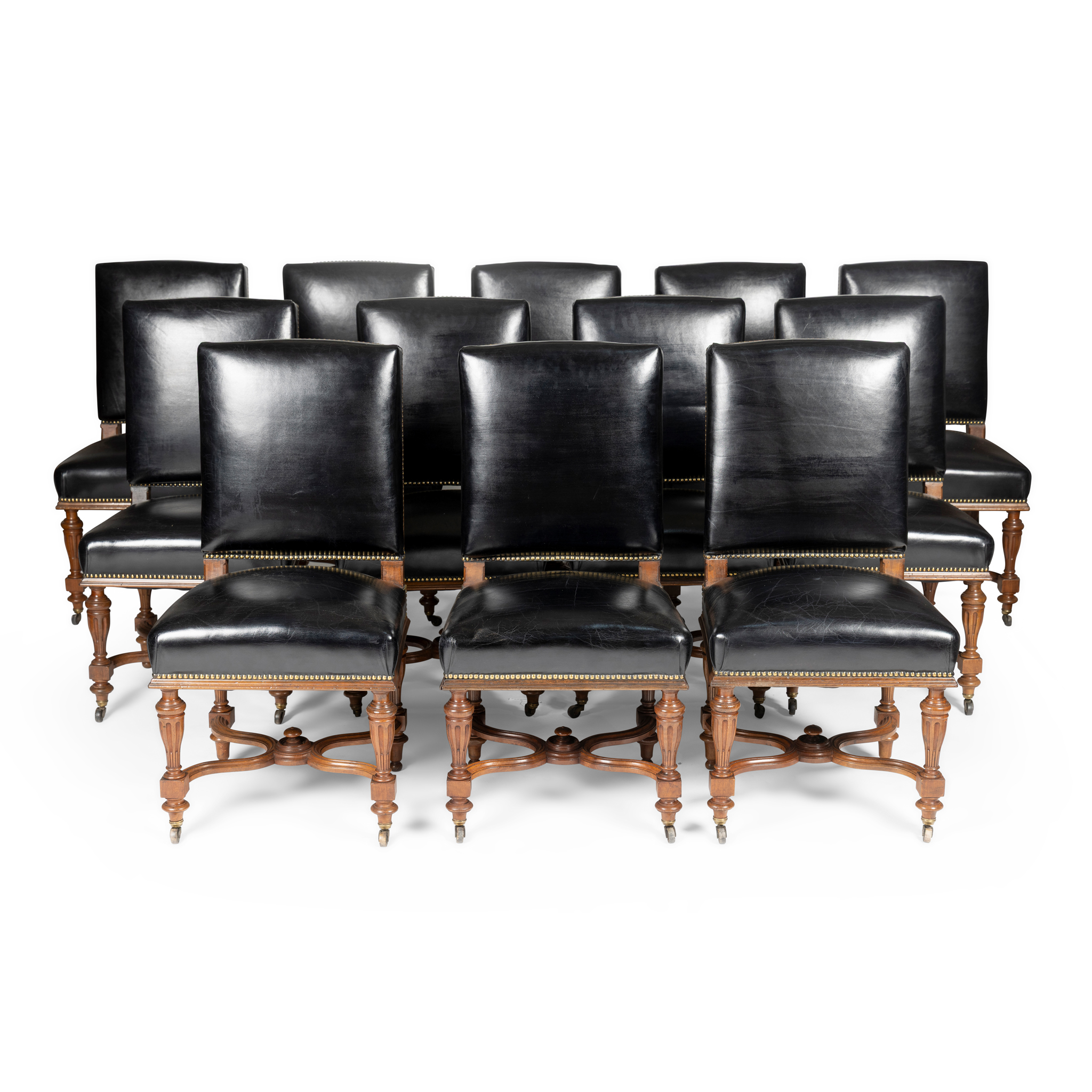 A SET OF TWELVE FRENCH WALNUT AND BLACK LEATHER UPHOLSTERED LIBRARY CHAIRS