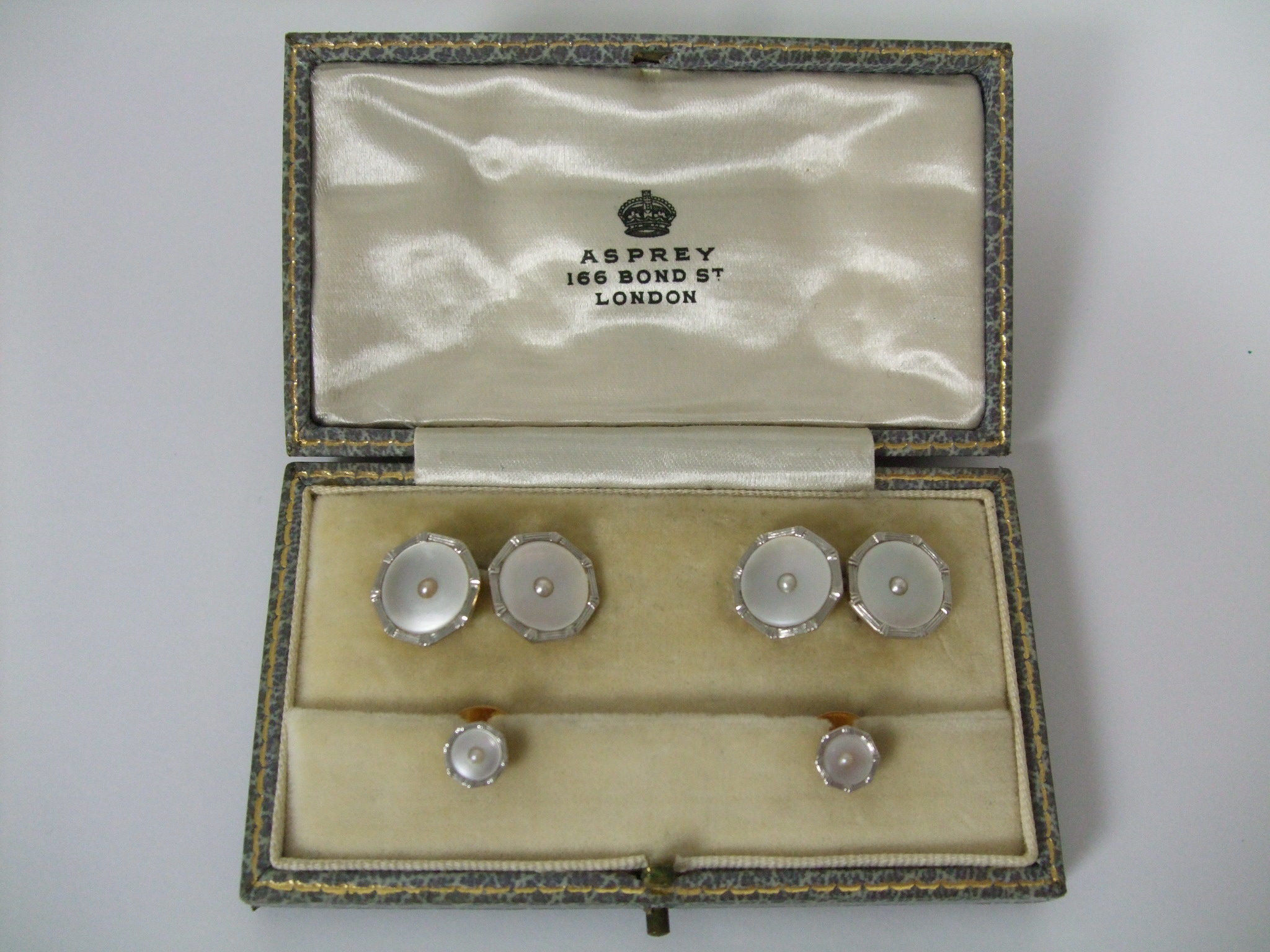 A cased Art Deco mother of pearl and seed pearl cufflinks and stud set