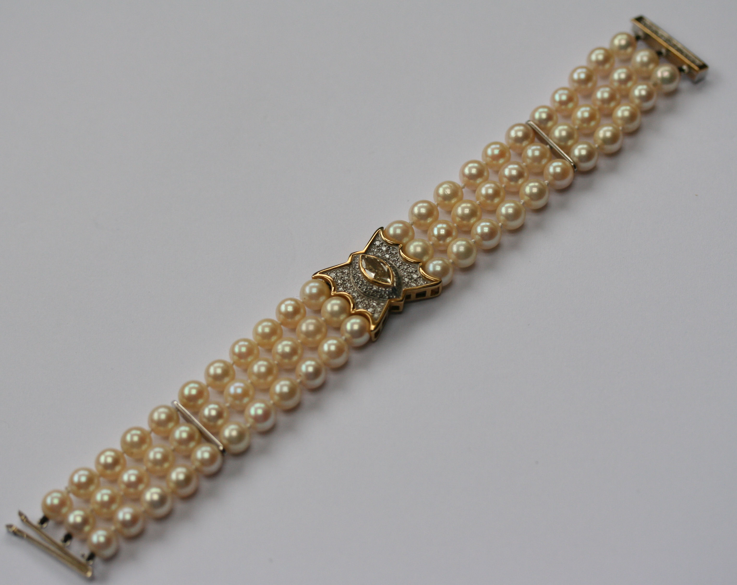 THEO FENNELL - a diamond and cultured pearl three-row bracelet
